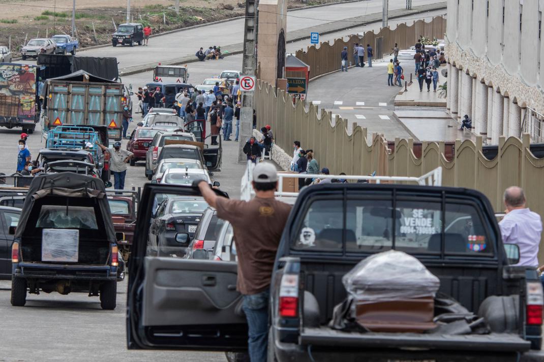 Individuos transportan los cuerpos de sus seres queridos en una lenta caravana fuera del Cementerio Jardines de la Esperanza para su entierro en Guayaquil, Ecuador, el 6 de abril el 2020.