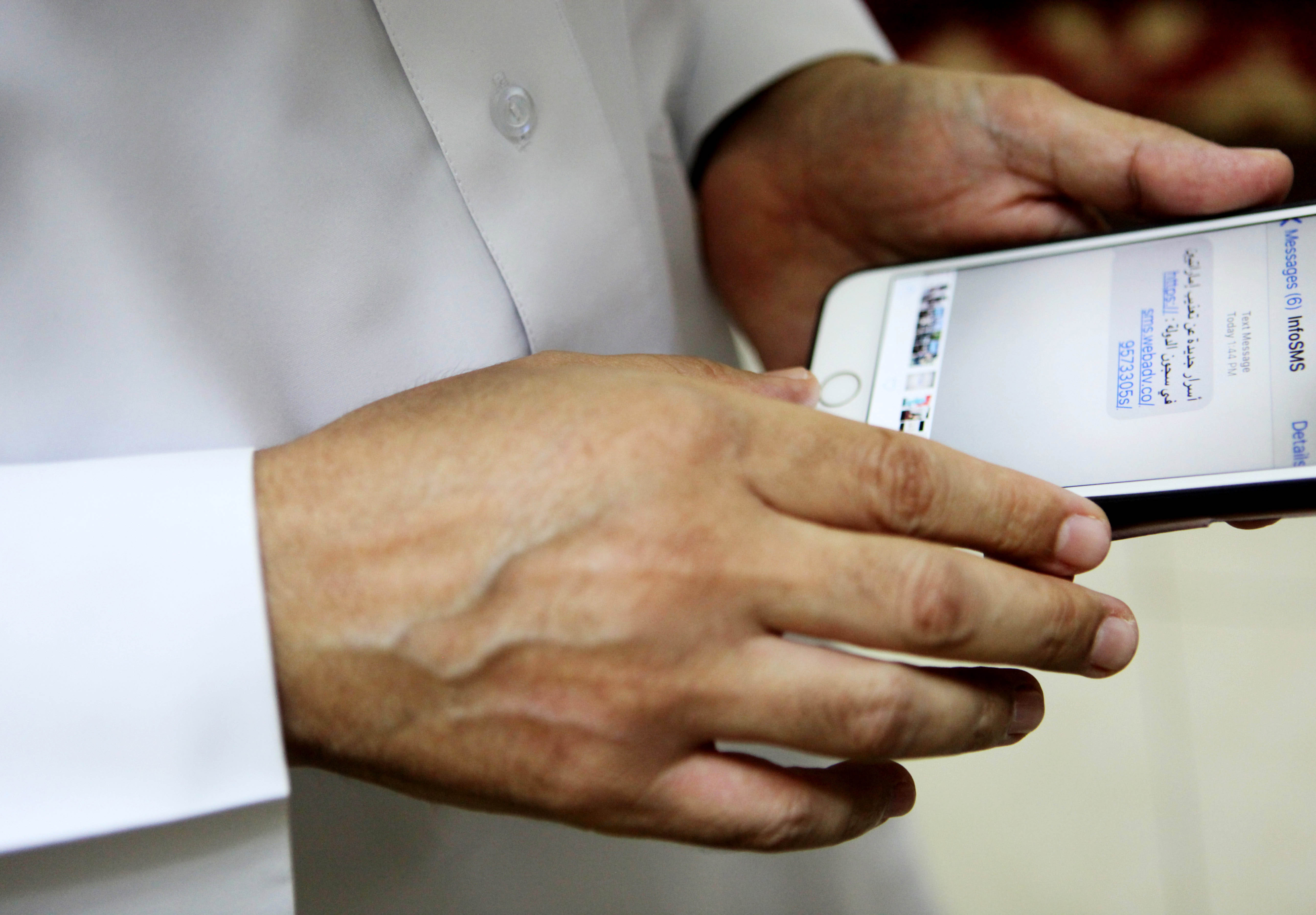 A man showing texts in Arabic on his phone