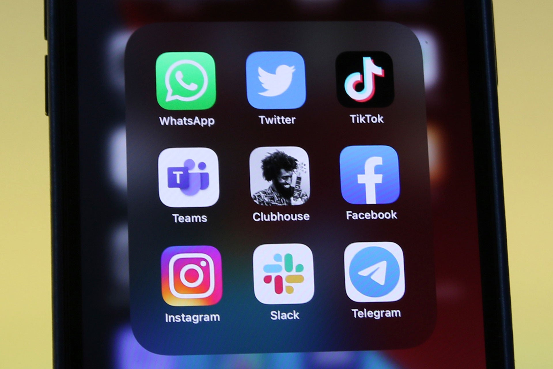 Logos of social media platforms including Clubhouse, center, are seen on an iPhone 12.