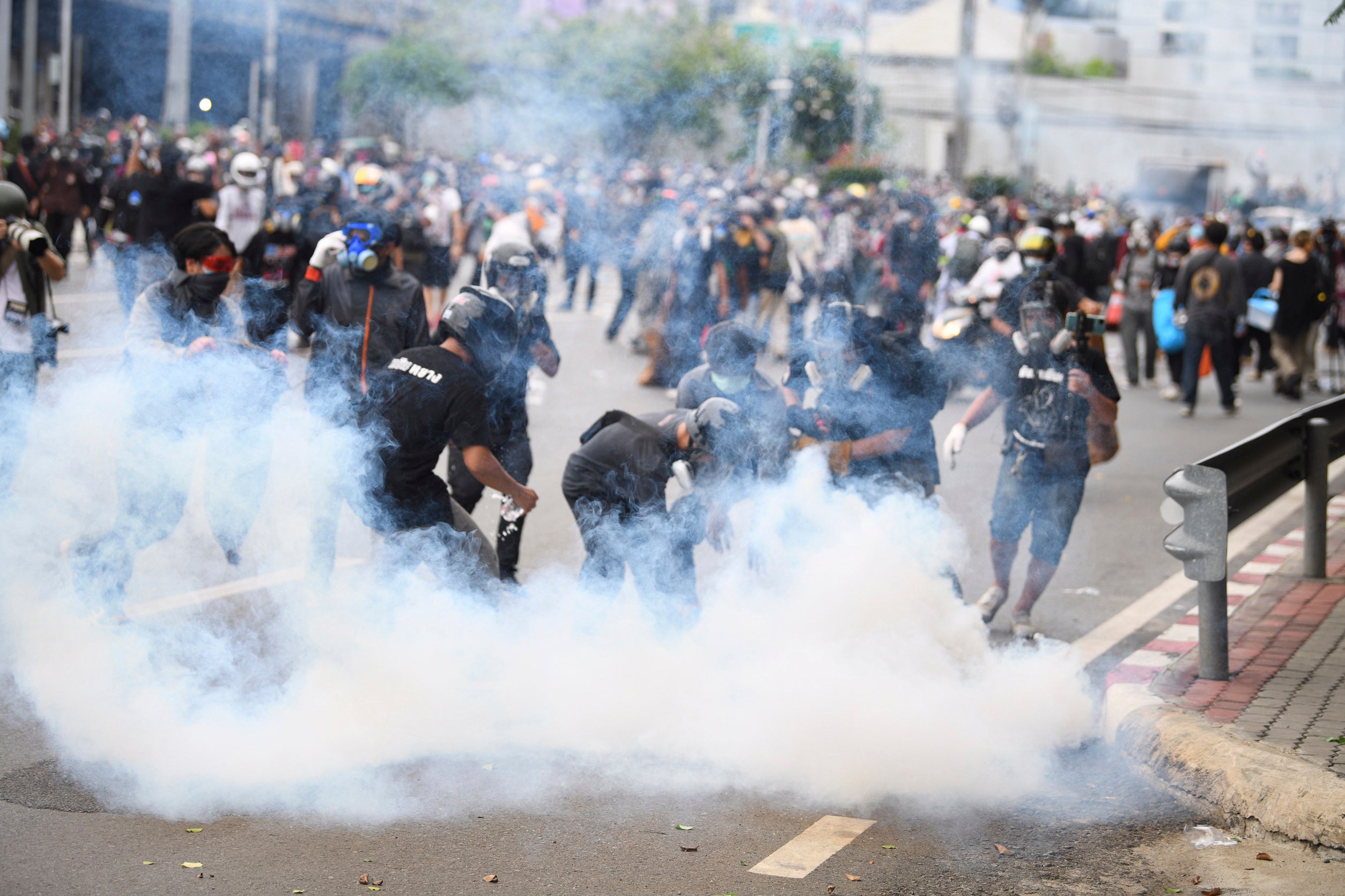 A crowd of protestors amongst teargas 