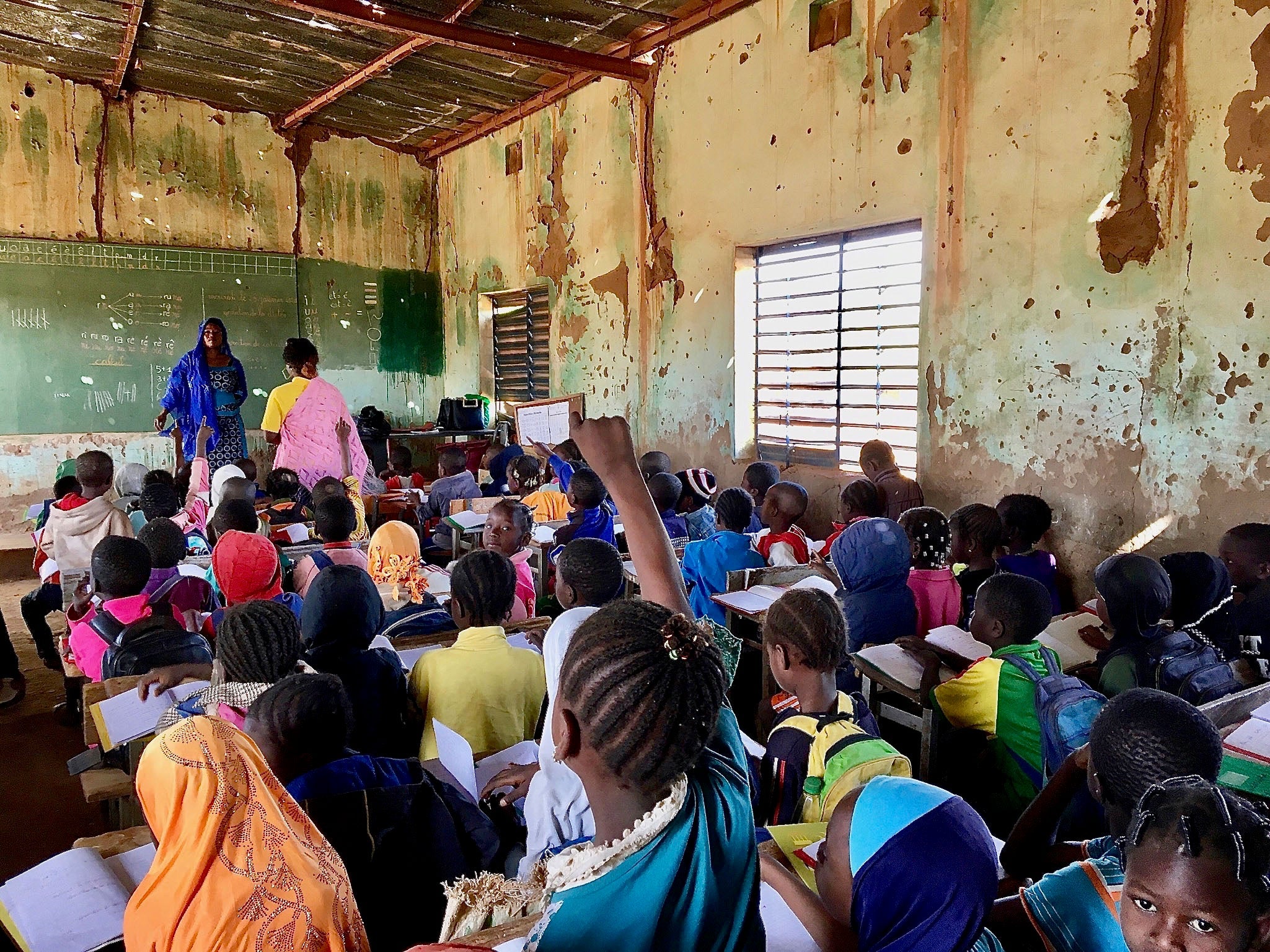 Une élève lève la main pour répondre à une question de son institutrice dans une salle de classe bondée d’une école primaire publique à Kaya, une ville de la région burkinabè du Centre-Nord qui accueille des dizaines de milliers de personnes déplacées. En janvier 2020, l’établissement comptait 748 élèves, dont 113 déplacés. « Chaque jour, des élèves déplacés viennent... Nous ne refusons pas d’inscriptions, mais s’il n’y a pas de places, ils ne peuvent pas commencer », a déploré le directeur de l’école. 