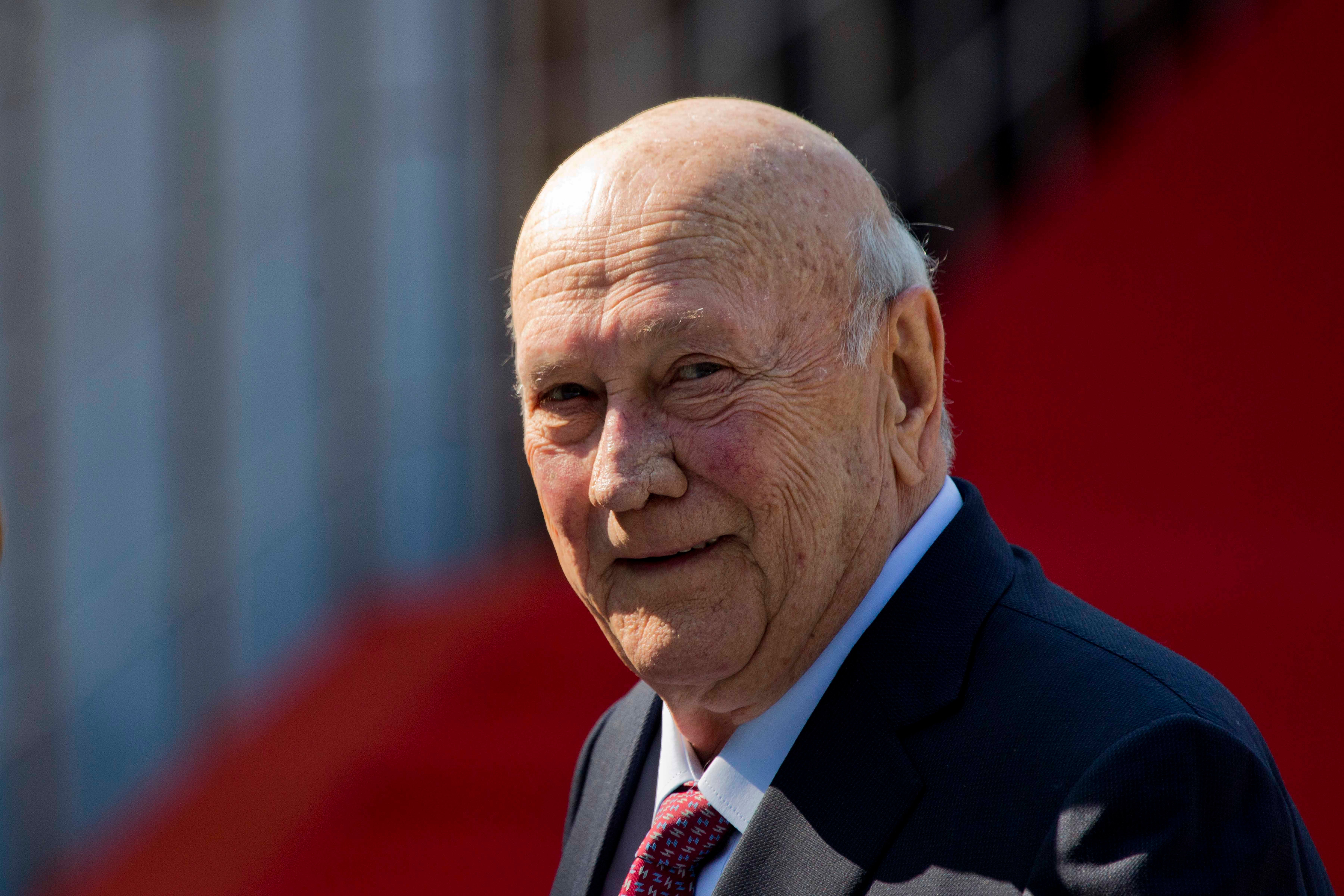 An elderly man smiles at the camera