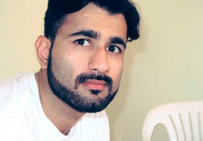 Photo of a man with black hair and a bear