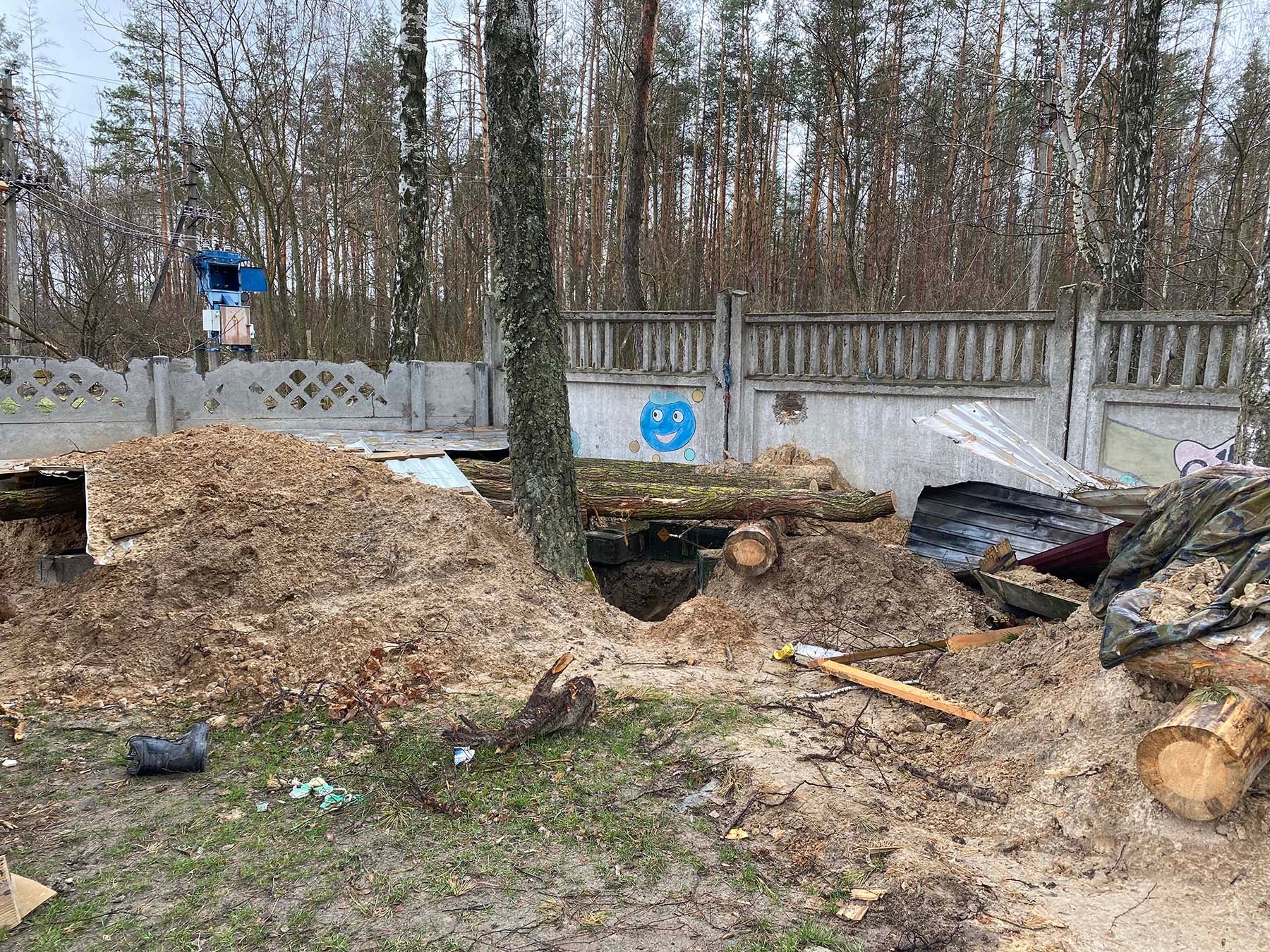 Russian forces dug pits and dugouts throughout the yard of Yahidne school and behind the school, while holding over 350 civilians in the school basement, Yahidne, April 17, 2022.