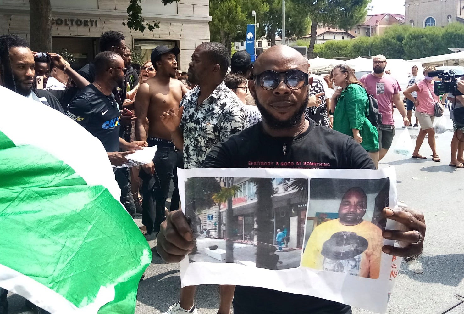 Un uomo mostra la foto della vittima Alika Ogorchukwu, venditore ambulante nigeriano, a Civitanova Marche, Italia, 30 luglio 2022.