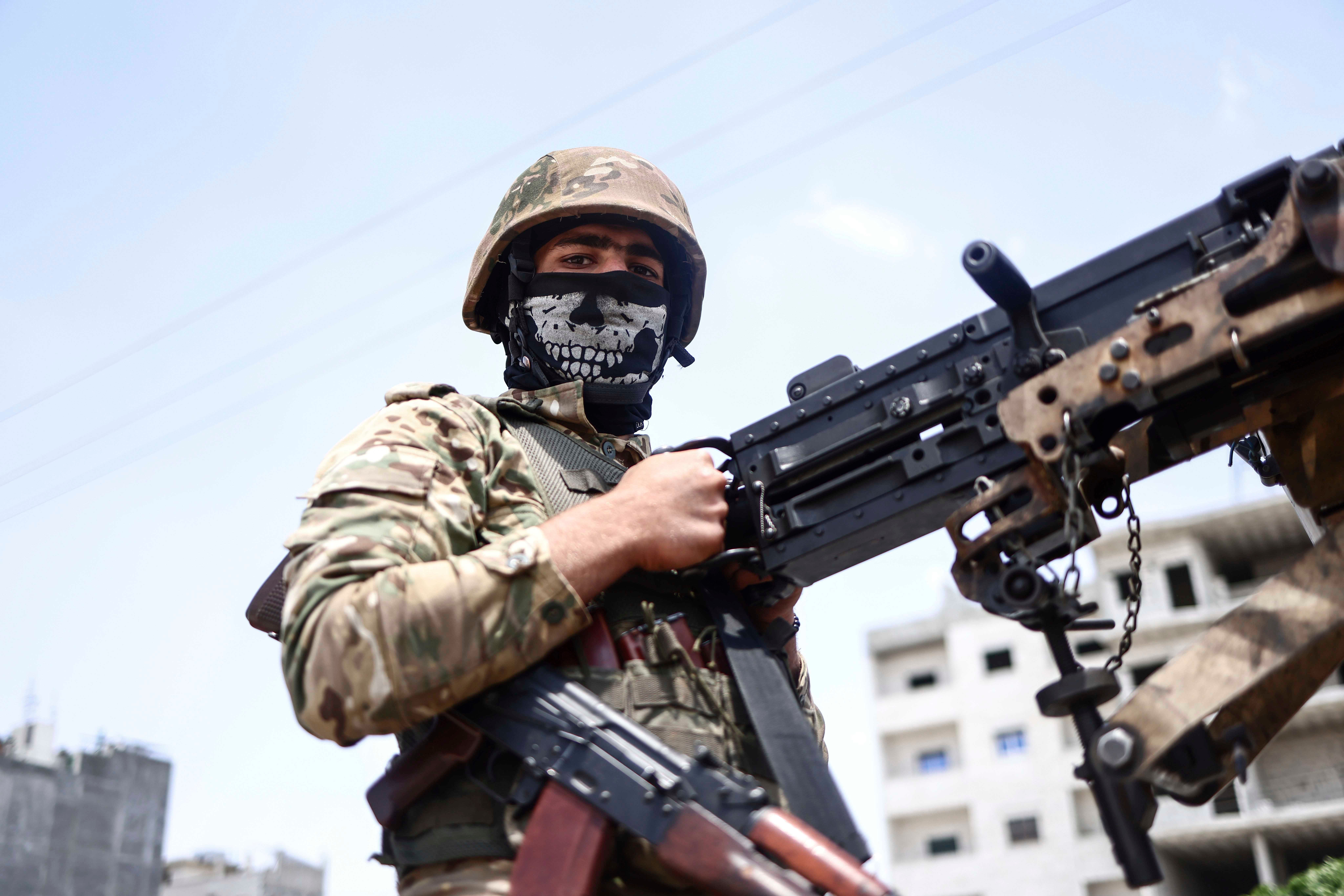 مقاتل من "الجيش الوطني السوري" المدعوم من سوريا يشارك في عرض عسكري في ريف محافظة حلب في 9 يونيو/حزيران 2022 كجزء من تحضيرات لعمل عسكري في المناطق التي تسيطر عليها "قوات سوريا الديمقراطية".
