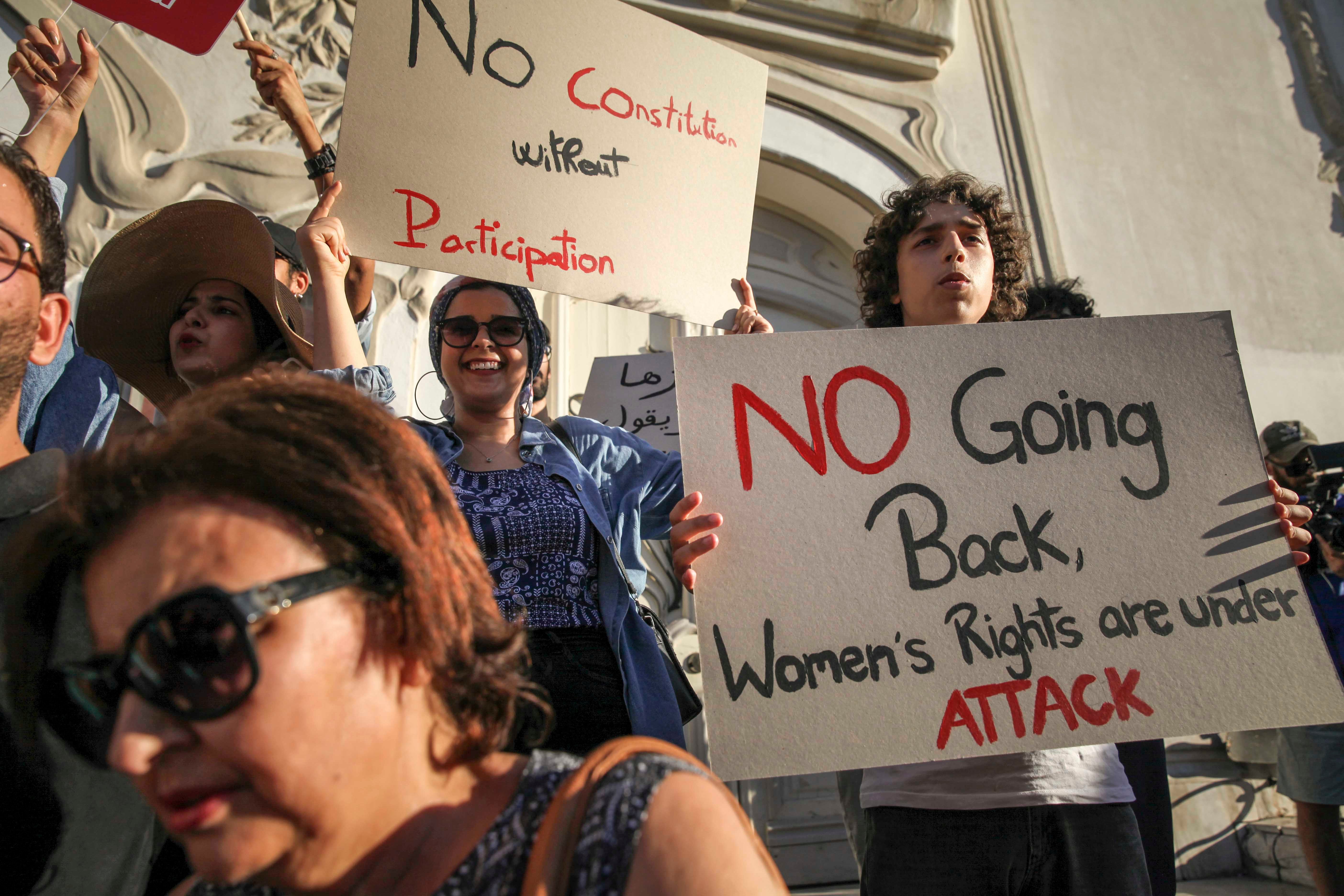 Une Tunisienne manifeste en brandissant une pancarte sur laquelle on peut lire : « Pas de retour en arrière, les droits des femmes sont attaqués », lors d'une protestation contre le président Saied sur l'avenue Habib Bourguiba à Tunis, le 22 juillet 2022. 