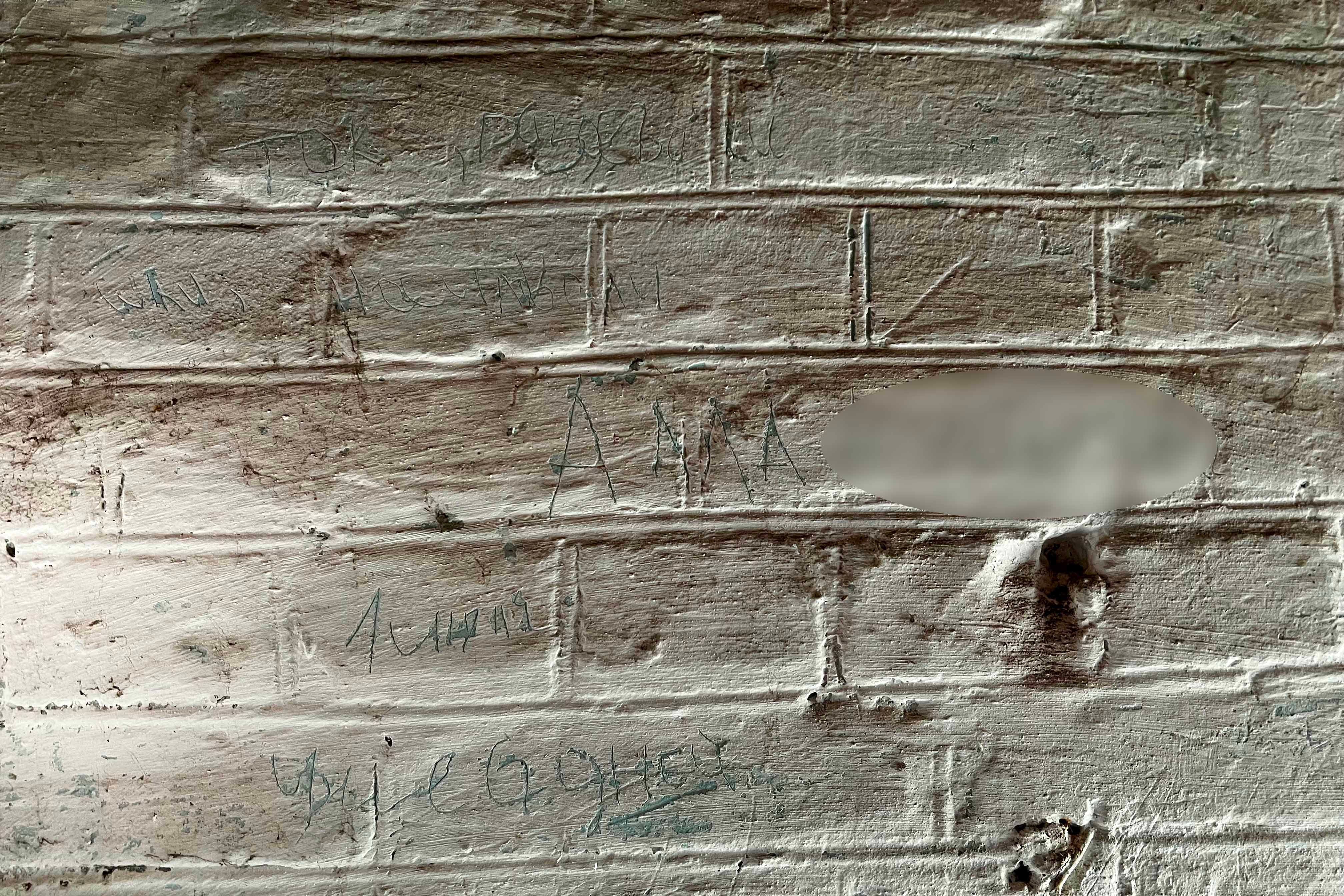 Una mujer que estuvo retenida en julio durante diez días en una pequeña habitación de un edificio del recinto de la Policlínica de Ferrocarriles de la Ciudad de Izium, inscribió su nombre completo en la pared, “Alla”, así como las palabras y frases “electricidad, desvestida o violada”, “apenas viva”, “asesinada”, “muy doloroso” y “ayuda”, 7 de octubre de 2022. 
