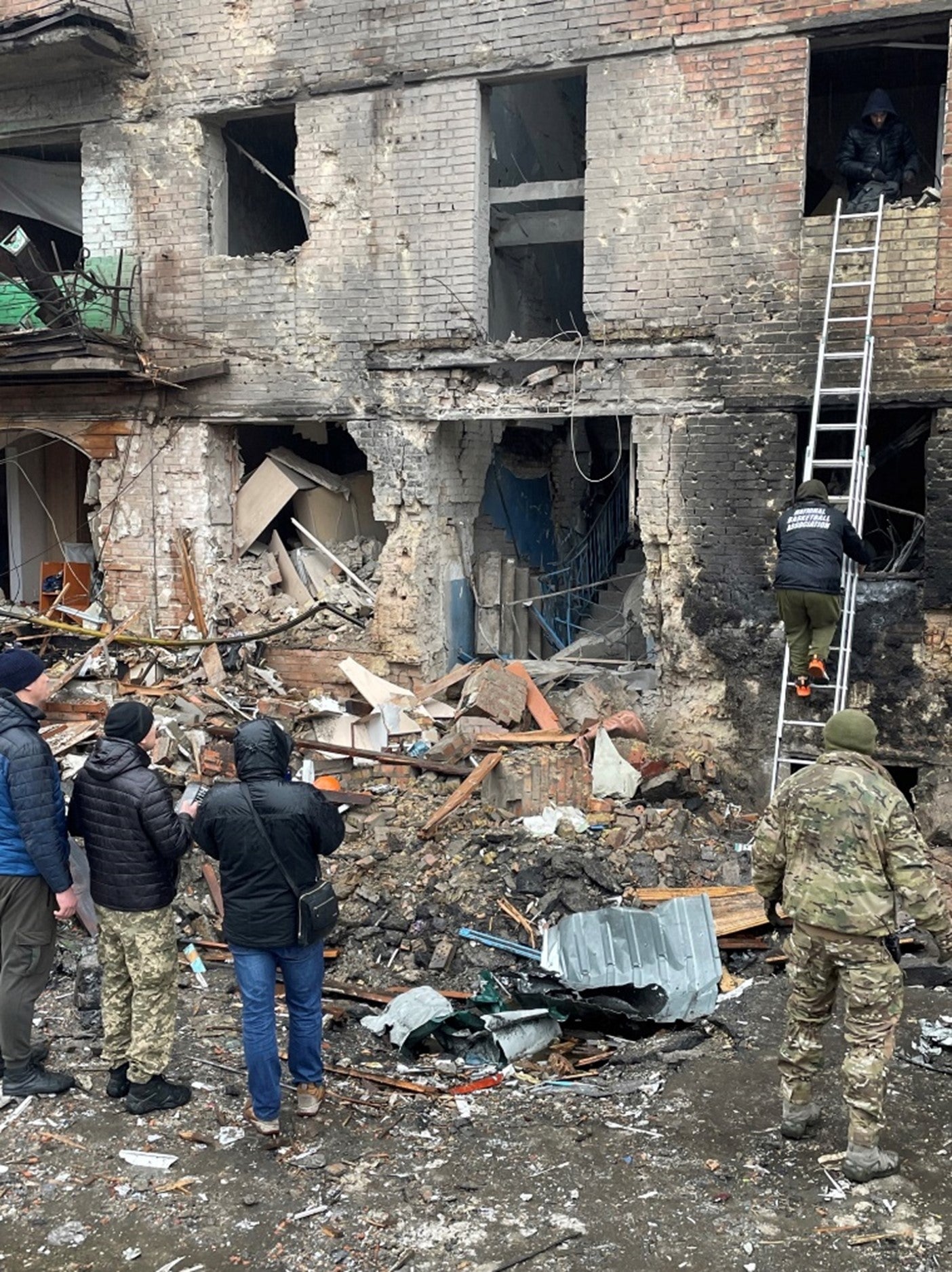 Рятувальники та місцеві мешканці біля будівлі на вул. Михайла Грушевського, 1, у Вишгороді. Будівлі на Михайла Грушевського, 3 та Михайла Грушевського, 5 також постраждали від вибухової хвилі. 24 листопада 2022 р. 