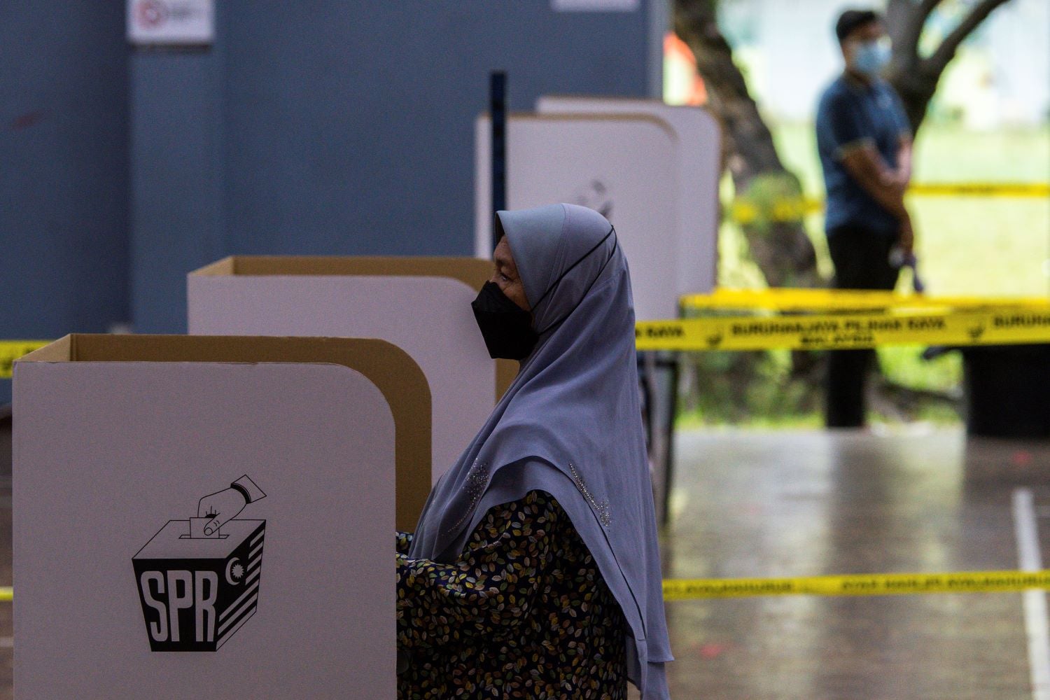 A woman casts her vote at a polling station for the 15th general election