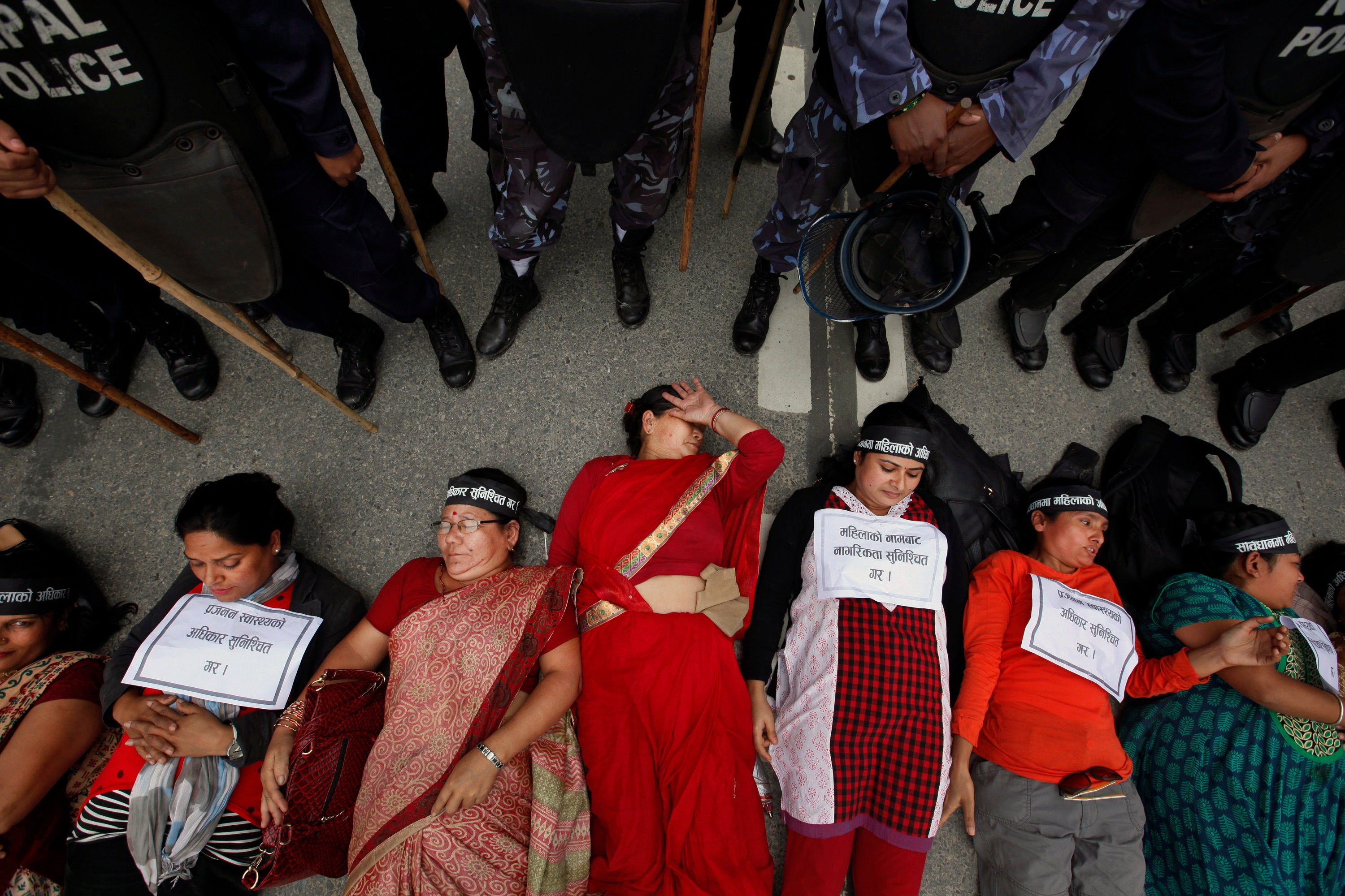 Sejumlah perempuan Nepal berbaring di tanah dalam sebuah aksi protes di Kathmandu, Nepal, untuk mengamendemen Undang-Undang Kewarganegaraan di negara tersebut, 7 Agustus 2015.