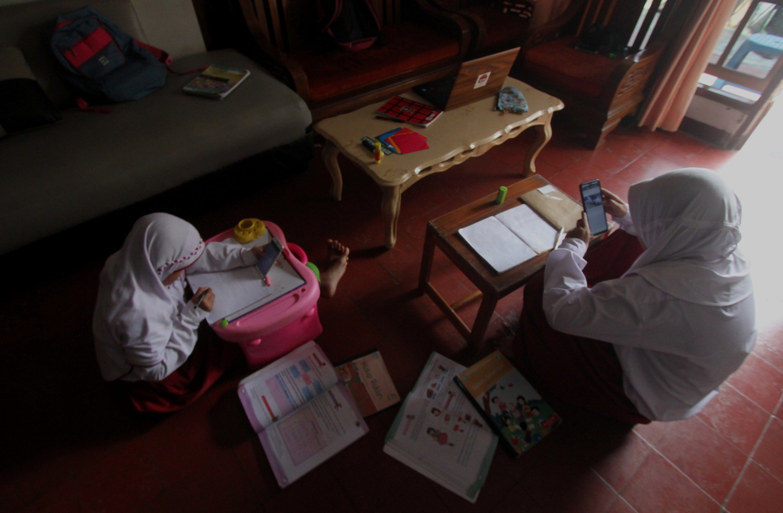 Students use mobile phones to do school tasks assigned by their teachers on an online learning system amid coronavirus pandemic in Jakarta, Indonesia.