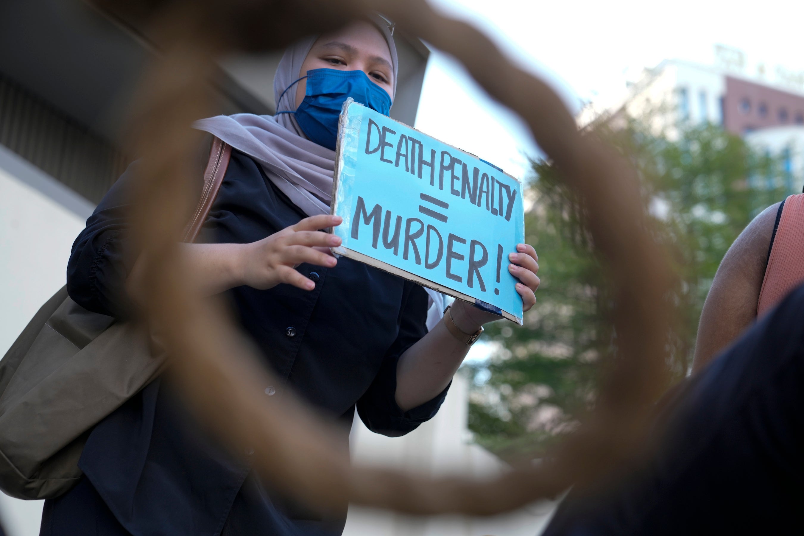 Une activiste tenait une petite pancarte avec le message « PEINE DE MORT = MEURTRE », lors d'une manifestation contre la peine de mort à Kuala Lumpur, en Malaisie, le 23 avril 2022. 