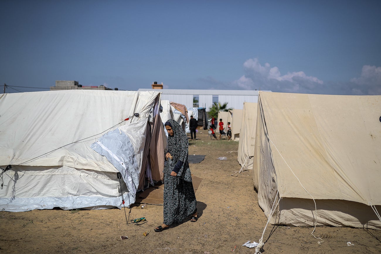 Une jeune fille marche autour des tentes d'un camp installé par l'Office de secours et de travaux des Nations Unies pour les réfugiés de Palestine (UNRWA) pour les Palestiniens qui ont fui dans le sud de la bande de Gaza, le 19 octobre 2023. 