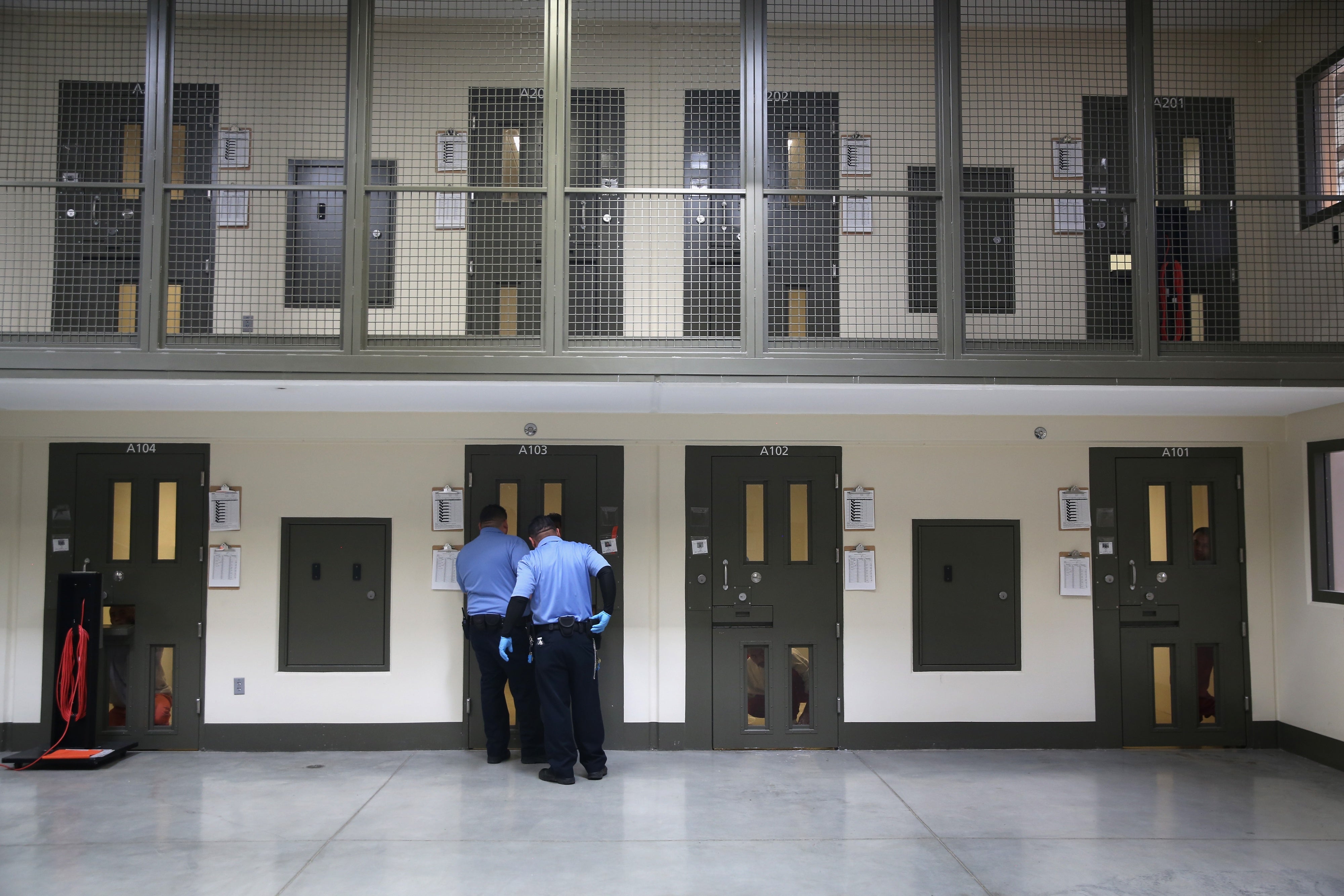 Guards prepare to escort an immigrant detainee from his 'segregation cell' back into the general population at the Adelanto Detention Facility, Adelanto, California, on November 15, 2013. 