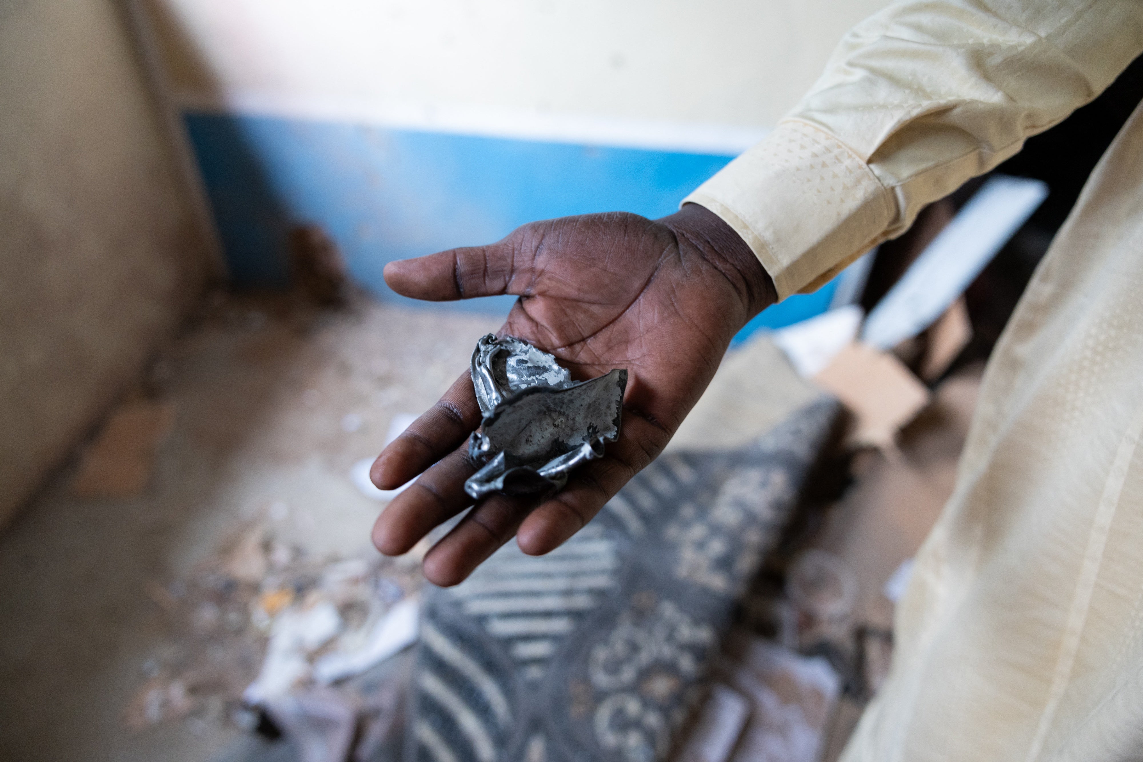 Un habitant du district de Ridina à N'Djamena montre les restes d'un projectile tombé sur une maison à N'Djamena le 9 mai 2024, après l'annonce des résultats provisoires de l'élection présidentielle au Tchad.