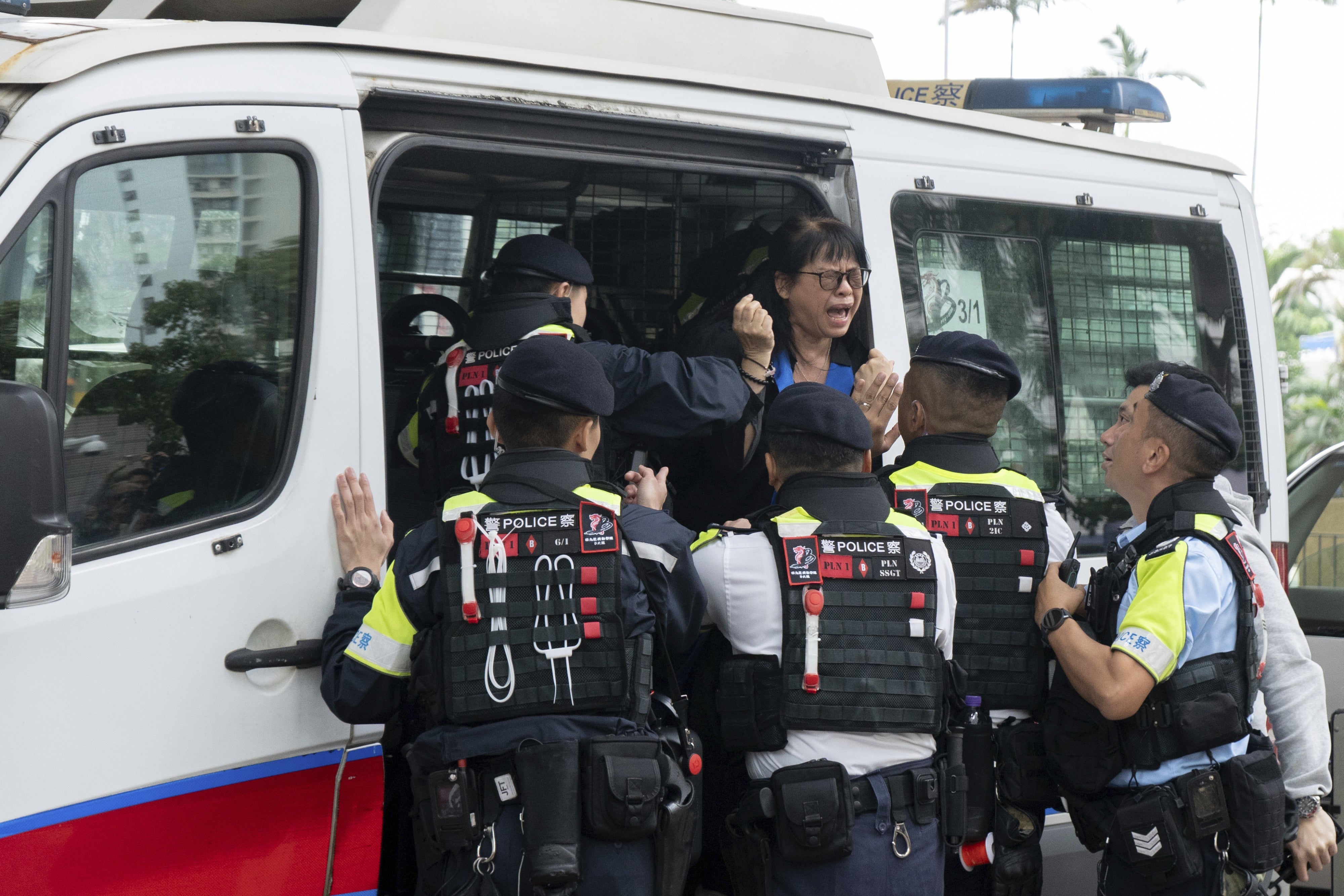 Elsa Wu, mère adoptive de l'activiste Hendrick Lui, était embarquée dans un fourgon de police peu après la condamnation de 45 militants pro-démocratie au Tribunal de première instance de West Kowloon à Hong Kong, le 19 novembre 2024.