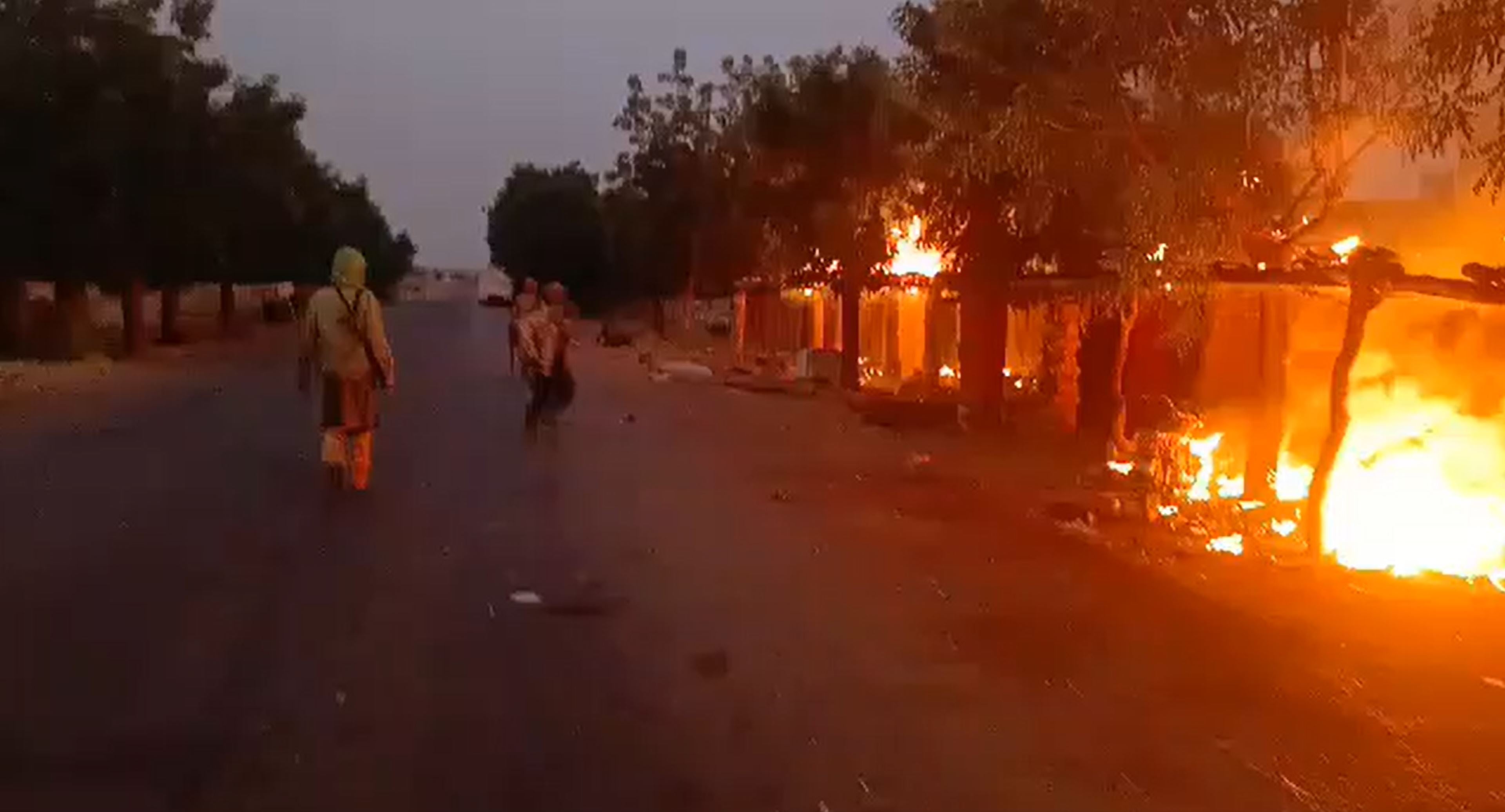 Capture d’écran d’une vidéo publiée sur des réseaux sociaux le 9 novembre 2024, que Human Rights Watch a analysée et geolocalisée comme correspondant au village d’Allaye-Kokolo, situé au bord de la Route nationale 15, entre Mopti et Bandiagara, au Mali. La vidéo montre des hommes armés, certains sur des motos, sur la route, entourés de bâtiments en feu. Un homme peut être entendu parlant le fulfuldé et disant « Dieu est grand, Allaye-Kokolo brûle. »