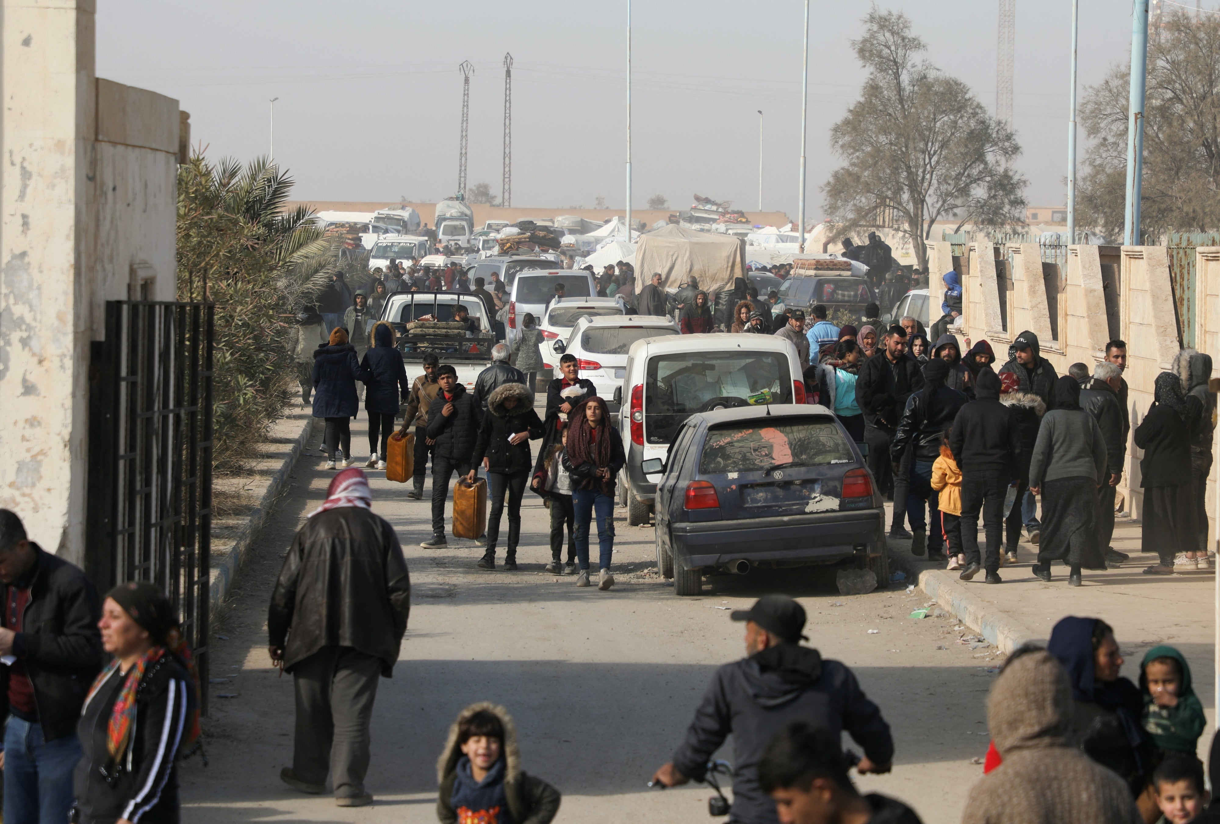 نازحون هربوا من ريف حلب يمشون في الطبقة، سوريا، 4 ديسمبر/كانون الأول 2024.