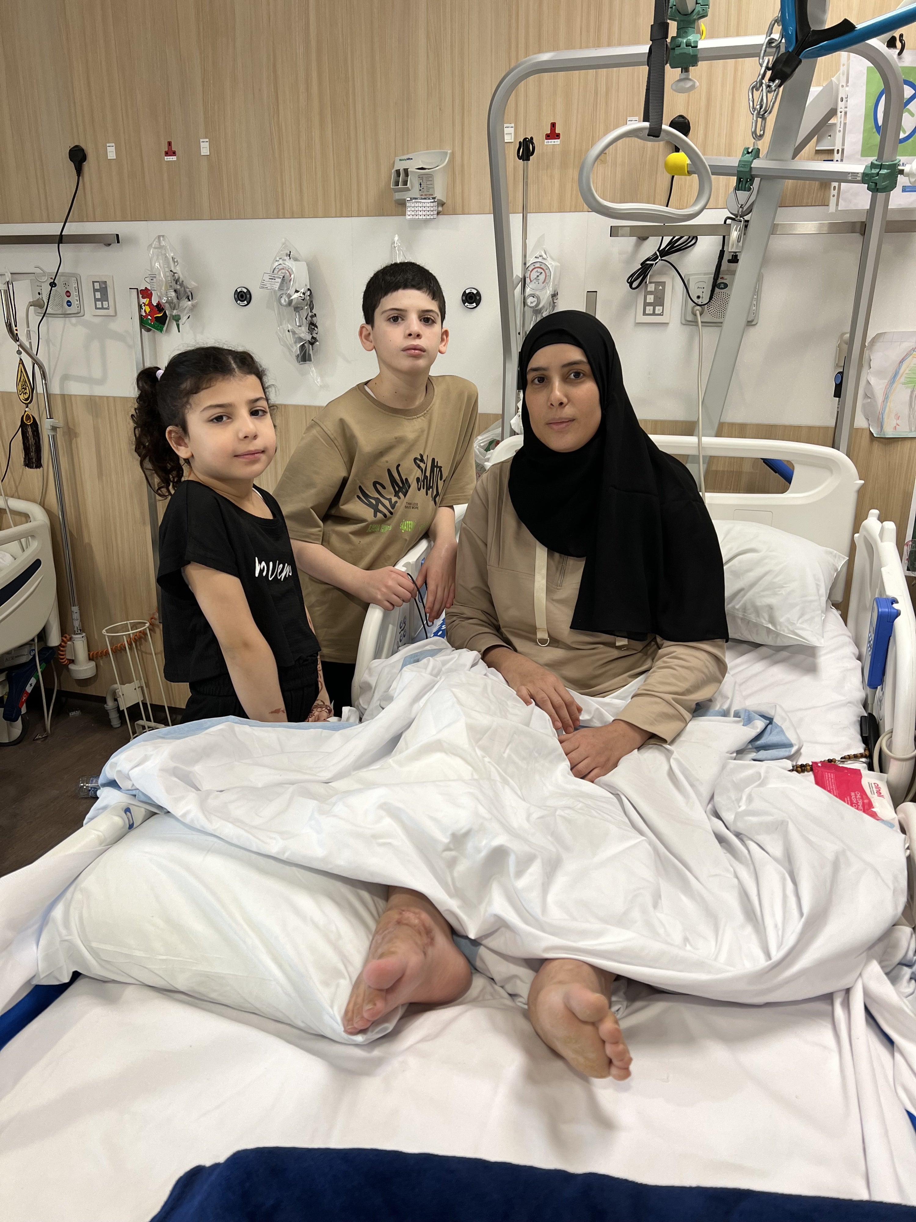 شيماء أبو جزر (يمين) مع طفليها حذيفة (وسط) ومريم في مستشفى بالدوحة، قطر، يونيو/حزيران 2024.