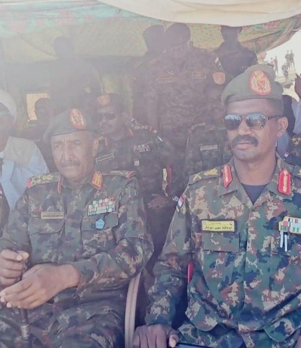 Le chef militaire Abou Akla Keikel (à droite), les épaulettes ornées de l’insigne de liwa’ (major général), assis à côté du général des FAS Abdelfattah Al-Burhan. Les deux hommes étaient vêtus de l’uniforme des FAS, sur cette photo publiée sur la page Facebook des Forces du Bouclier du Soudan, le 23 décembre 2024.