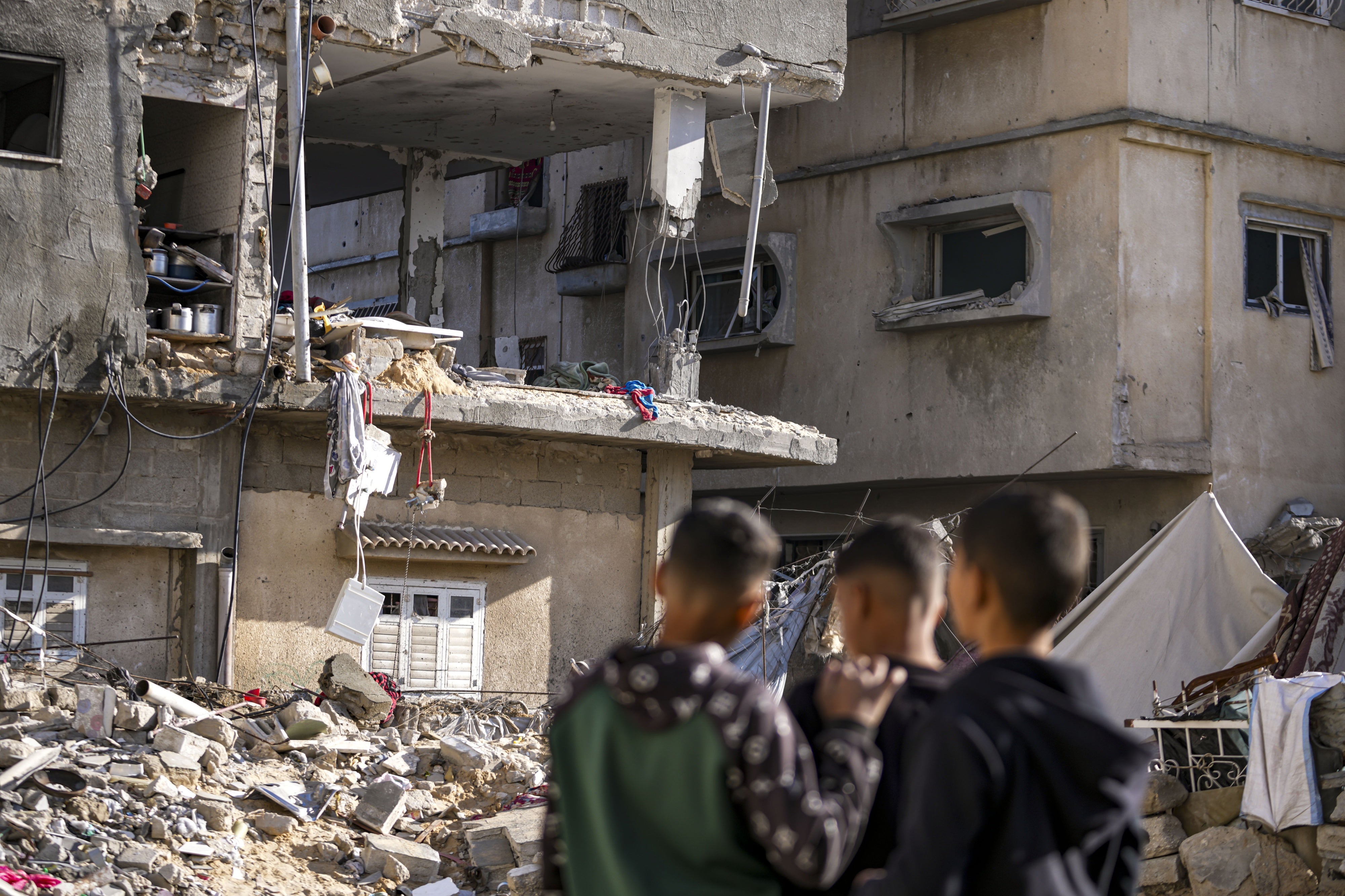 Trois garçons regardaient les décombres d’un immeuble résidentiel touché la veille par une frappe israélienne à Deir al-Balah, dans la bande de Gaza, le 8 janvier 2025.