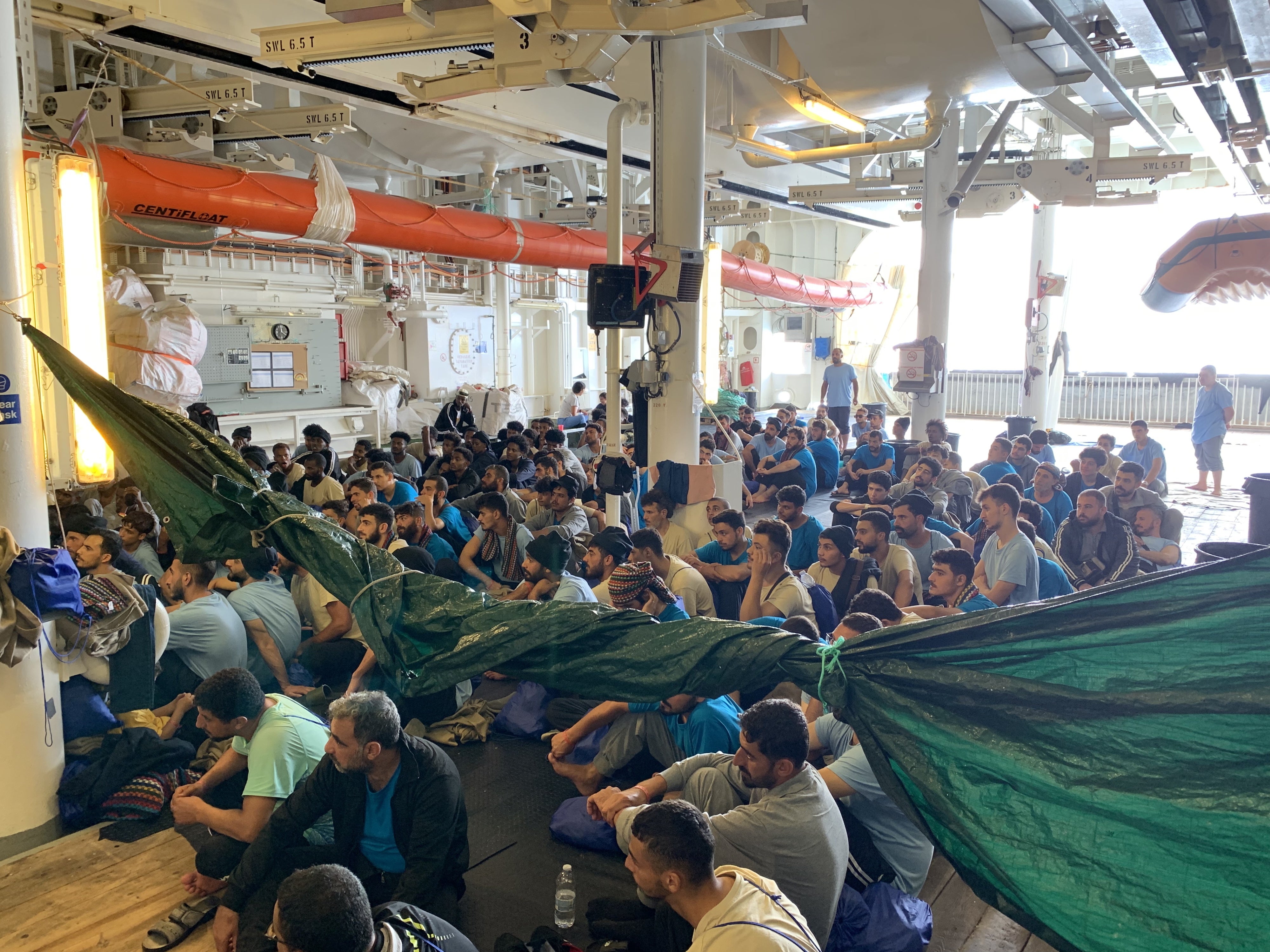 Gli uomini sopravvissuti sul ponte coperto della Geo Barents ascoltano le informazioni dell’equipaggio di MSF, 20 settembre 2024.