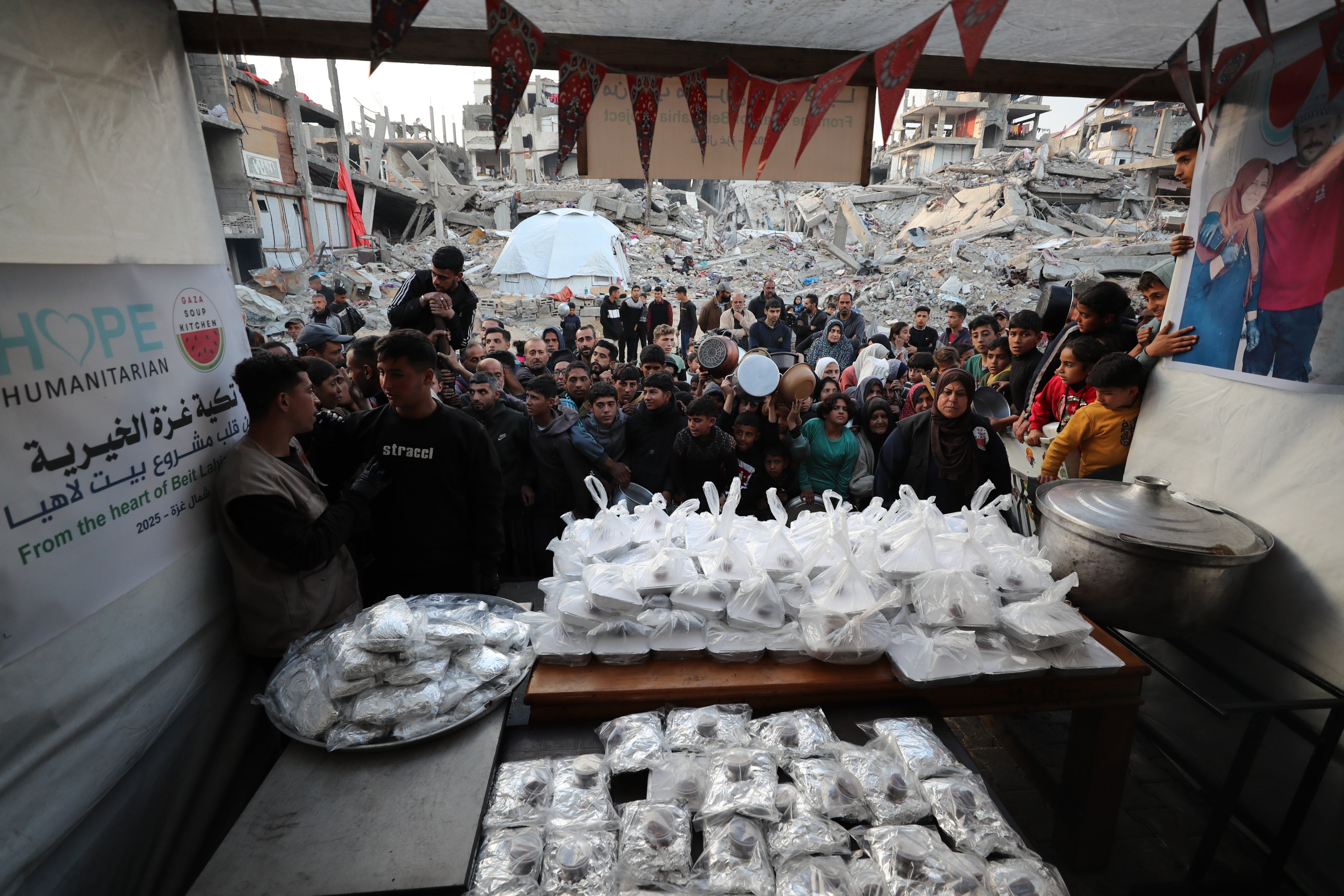 Des Palestiniens font la queue pour recevoir des repas chauds au camp de réfugiés de Jabalia, à Gaza, le 4 mars 2025.