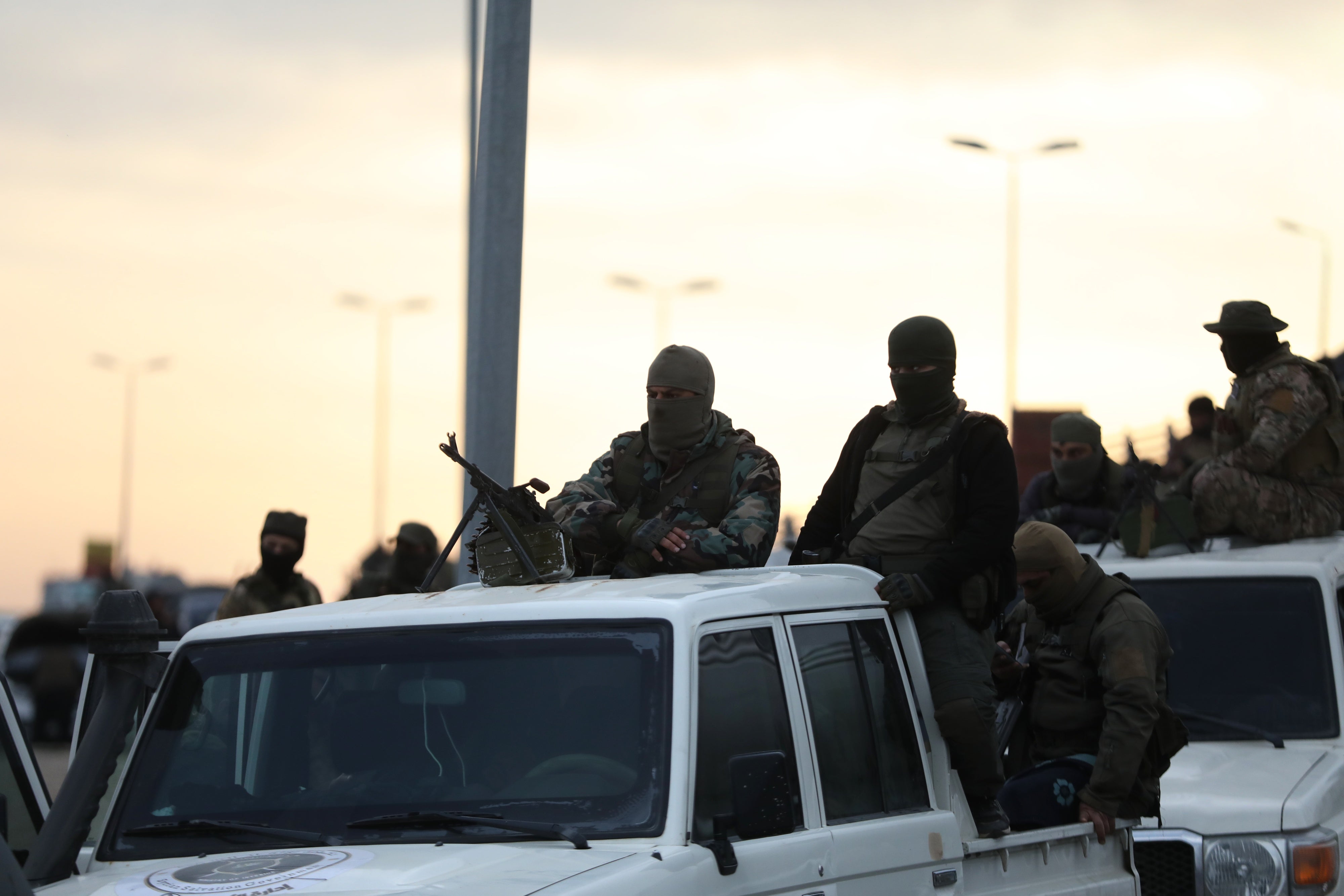 Fighters with the new Syrian government ride in trucks in Tartus, Syria, March 7, 2025, 