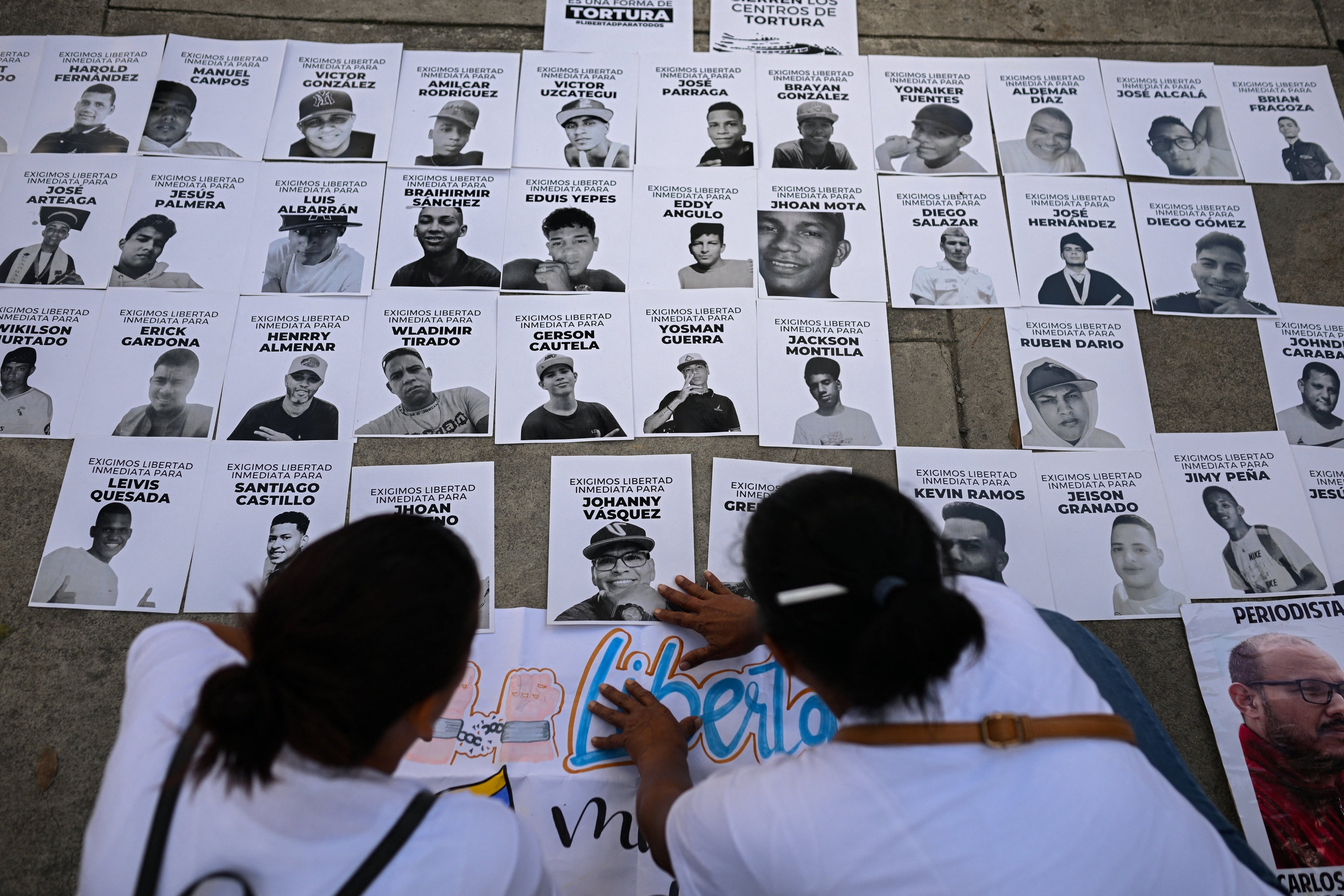People posting photos of detainees on a wall