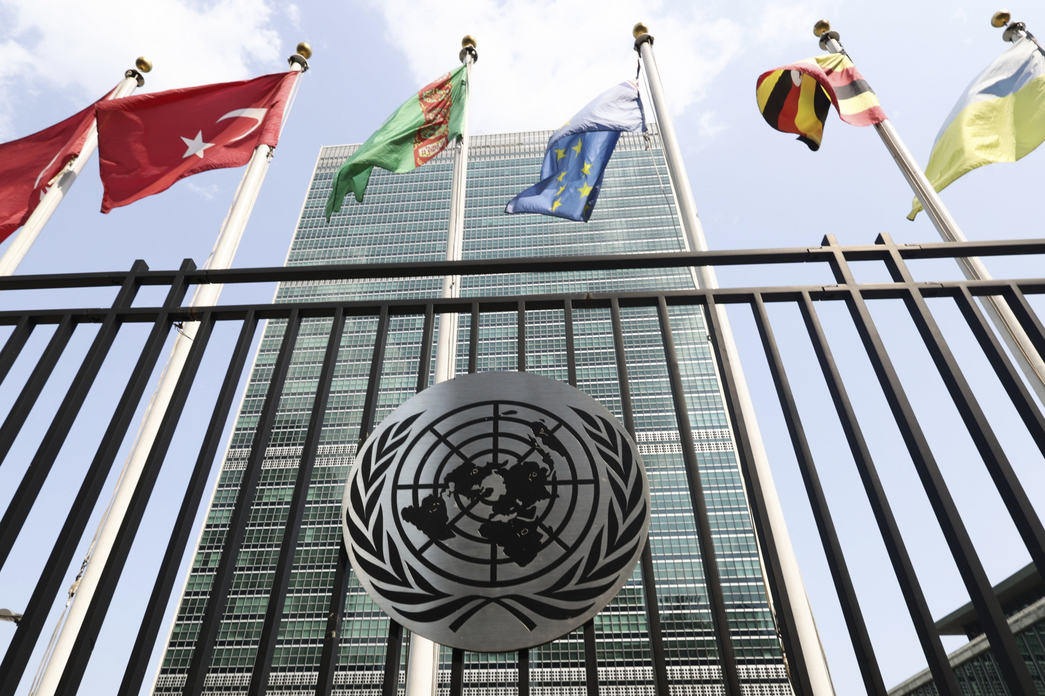 Les drapeaux de plusieurs pays flottaient au-dessus de l’emblème des Nations Unies devant le siège de l’ONU à New York, le 16 juillet 2024.