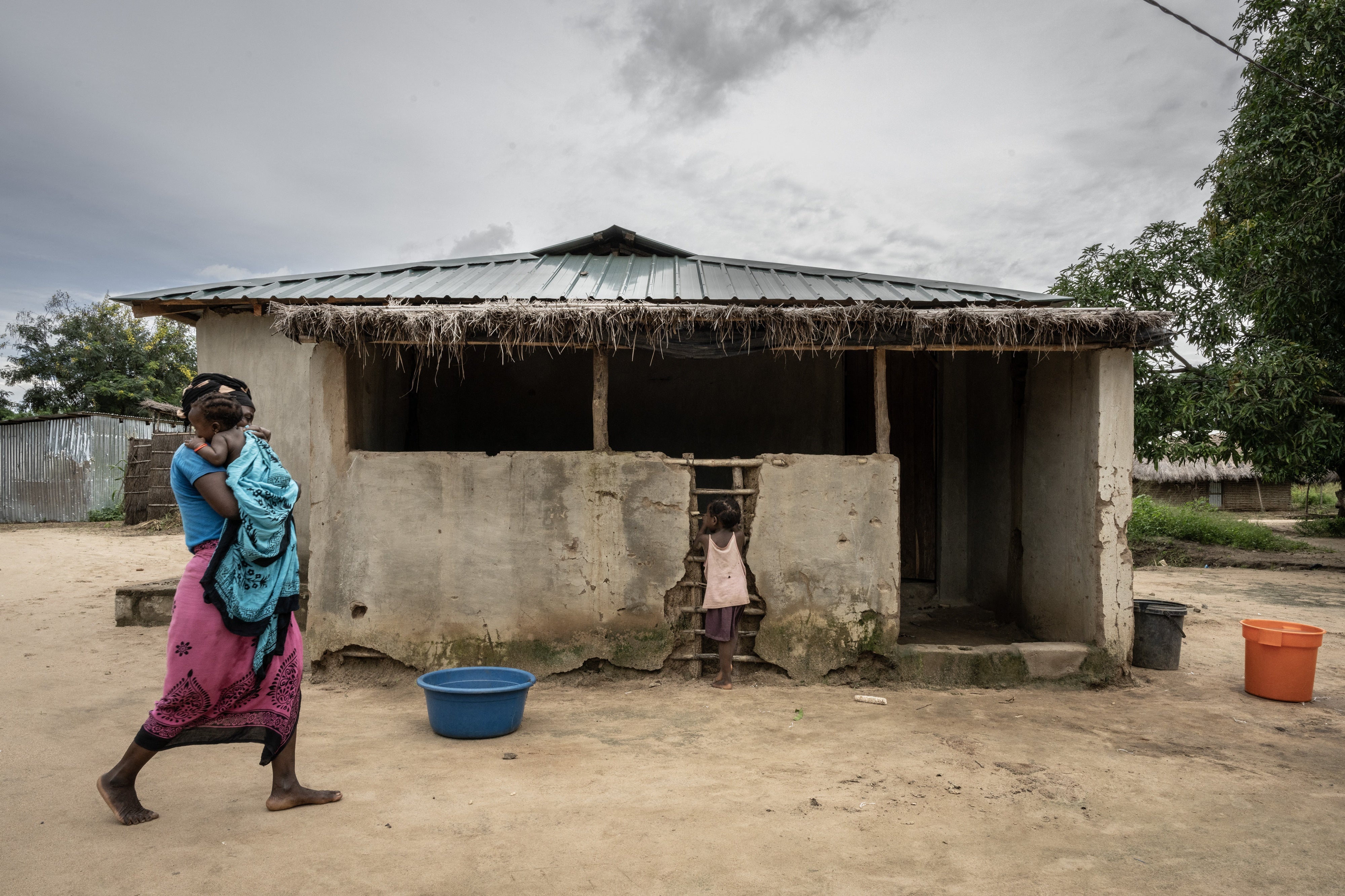 Uma mãe caminha com suas filhas na comunidade de Saul, na região de Metuge, província de Cabo Delgado, em Moçambique, em 26 de março de 2024.