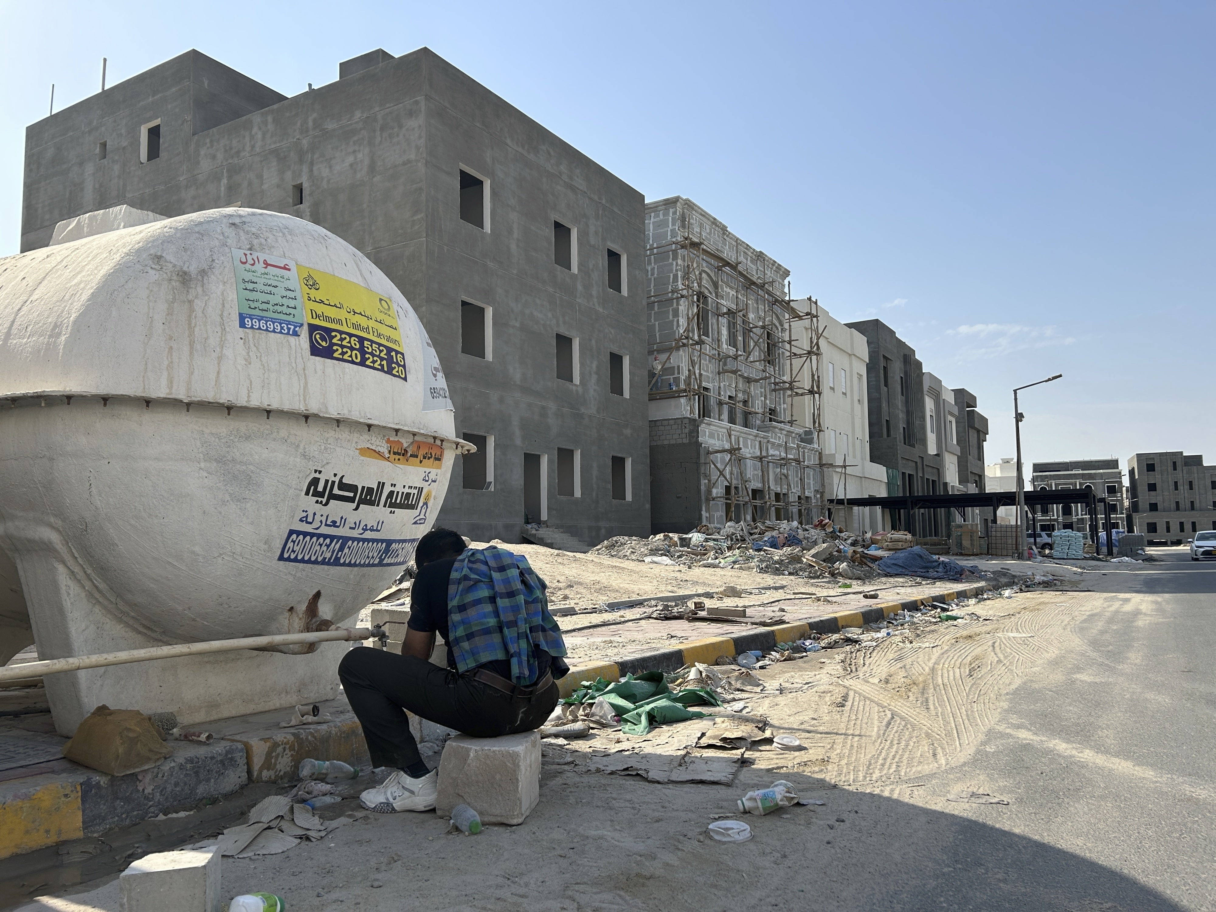 عامل بناء يغسل يديه ووجهه بعد انتهاء نوبة عمله في الفروانية، الكويت، 8 أغسطس/آب 2024. 