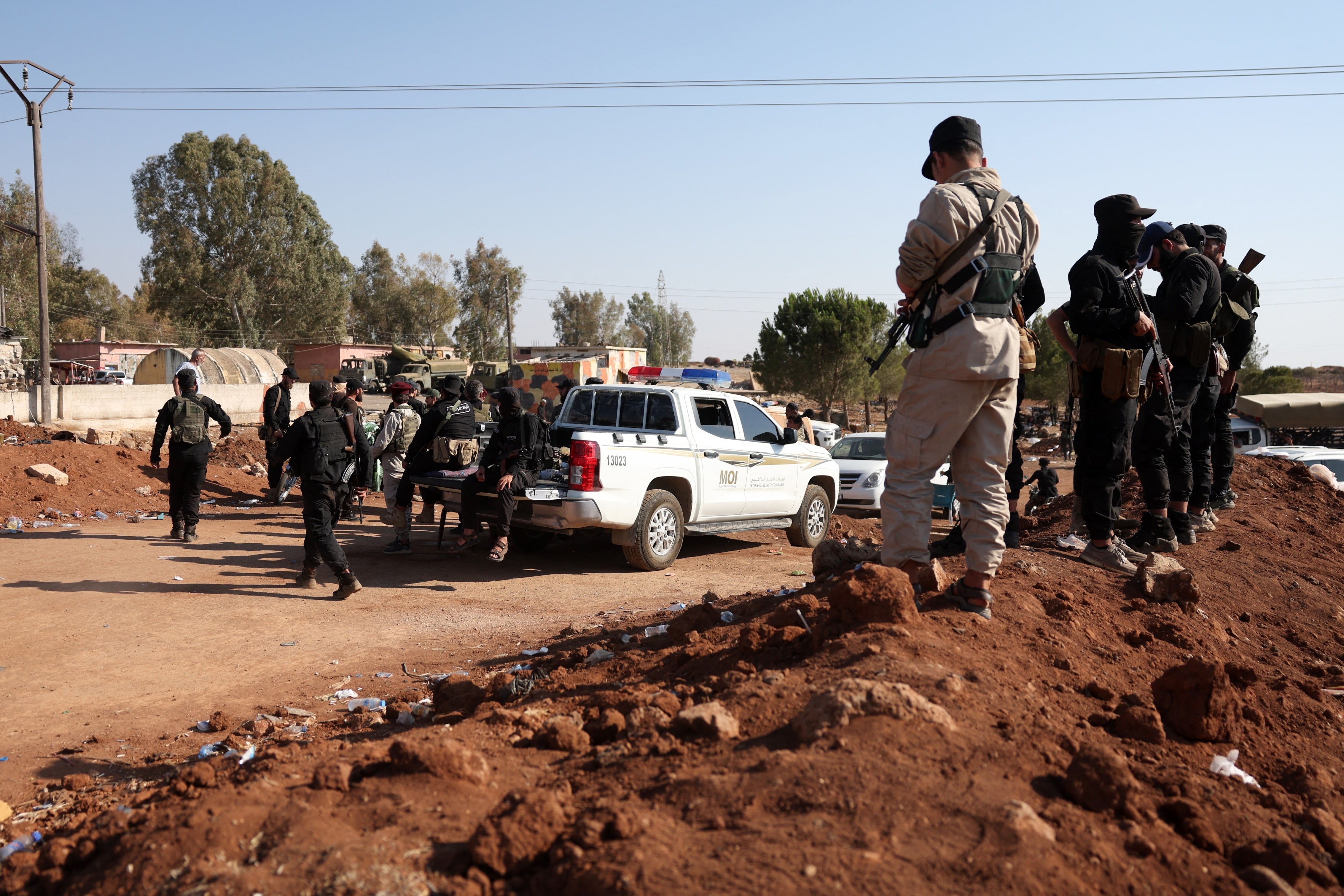 Des membres des forces de sécurité syriennes surveillaient les environs à Busra al-Harir, dans la province de Deraa qui jouxte la province de Soueïda dans le sud de la Syrie, le 21 juillet 2025. 
