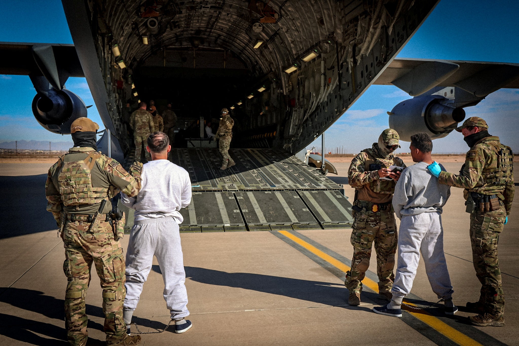 The first US military aircraft to carry detained migrants to a detention facility at Guantanamo Bay is boarded from an unspecified location in the US, February 4, 2025.