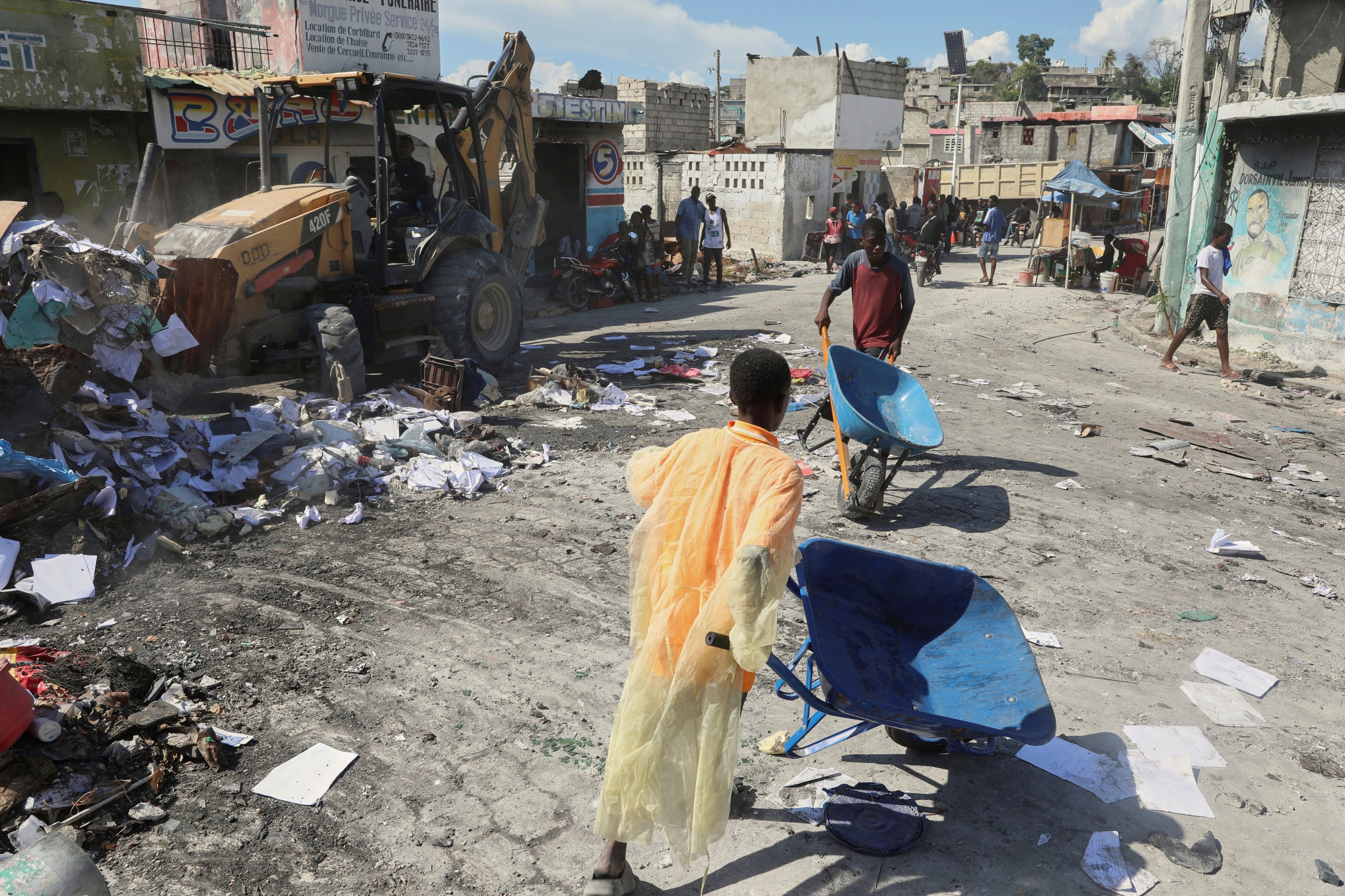 Haiti jóvenes utilizan carretillas para sacar escombros de sus hogares