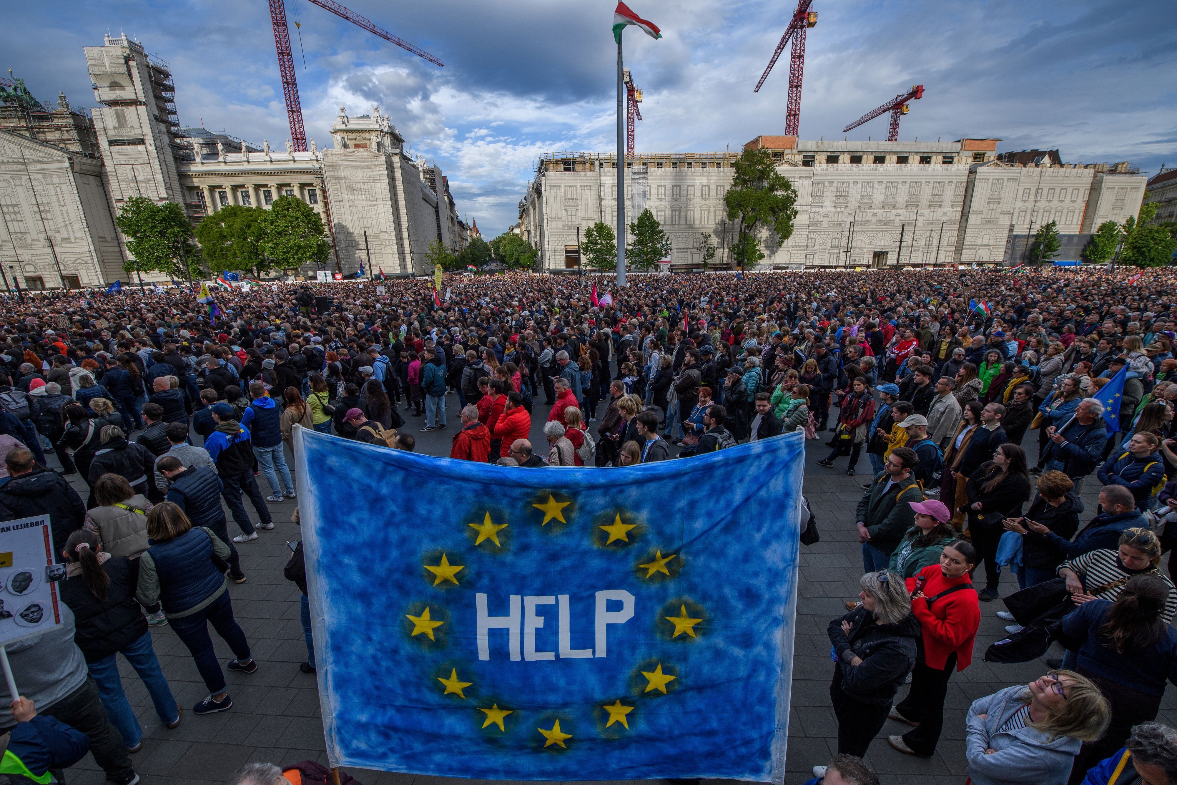 Un manifestante sostiene una bandera de la UE con la palabra “ayuda" escrita en ella, durante una manifestación en Budapest el 18 de mayo de 2025 contra un proyecto de ley que faculta al Gobierno para sancionar a las organizaciones de la sociedad civil y a los medios de comunicación que considere una amenaza para la soberanía del país.