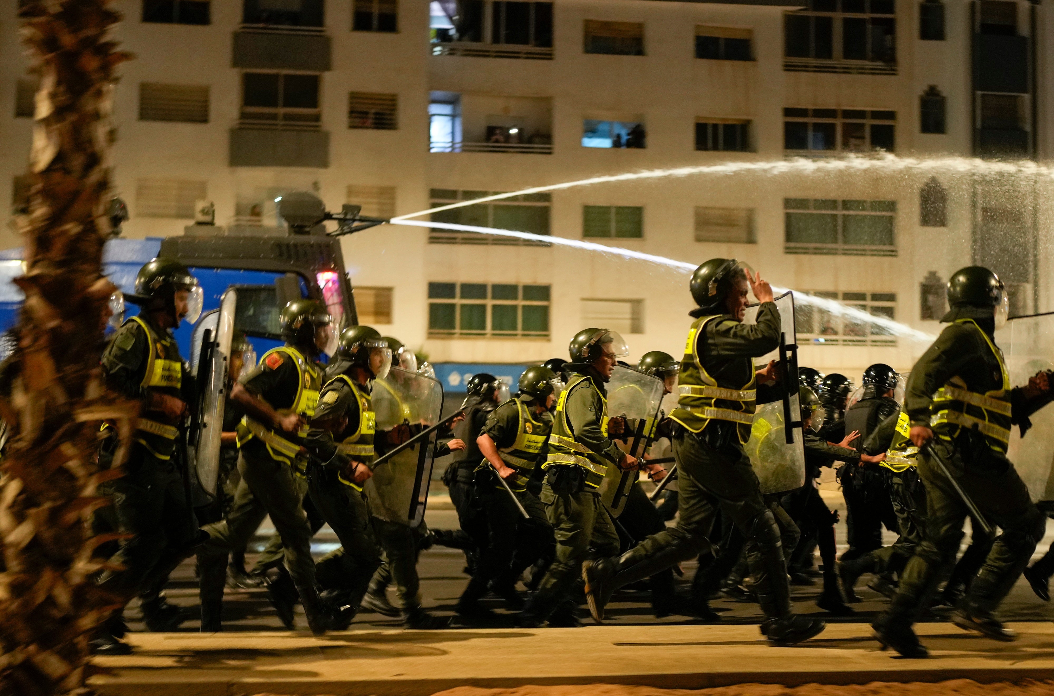 Des membres des forces de sécurité avançaient devant un véhicule utilisant un canon à eau pour disperser des jeunes manifestants réclamant des réformes des soins de santé et de l'éducation, à Salé, au Maroc, le 1er octobre 2025. 
