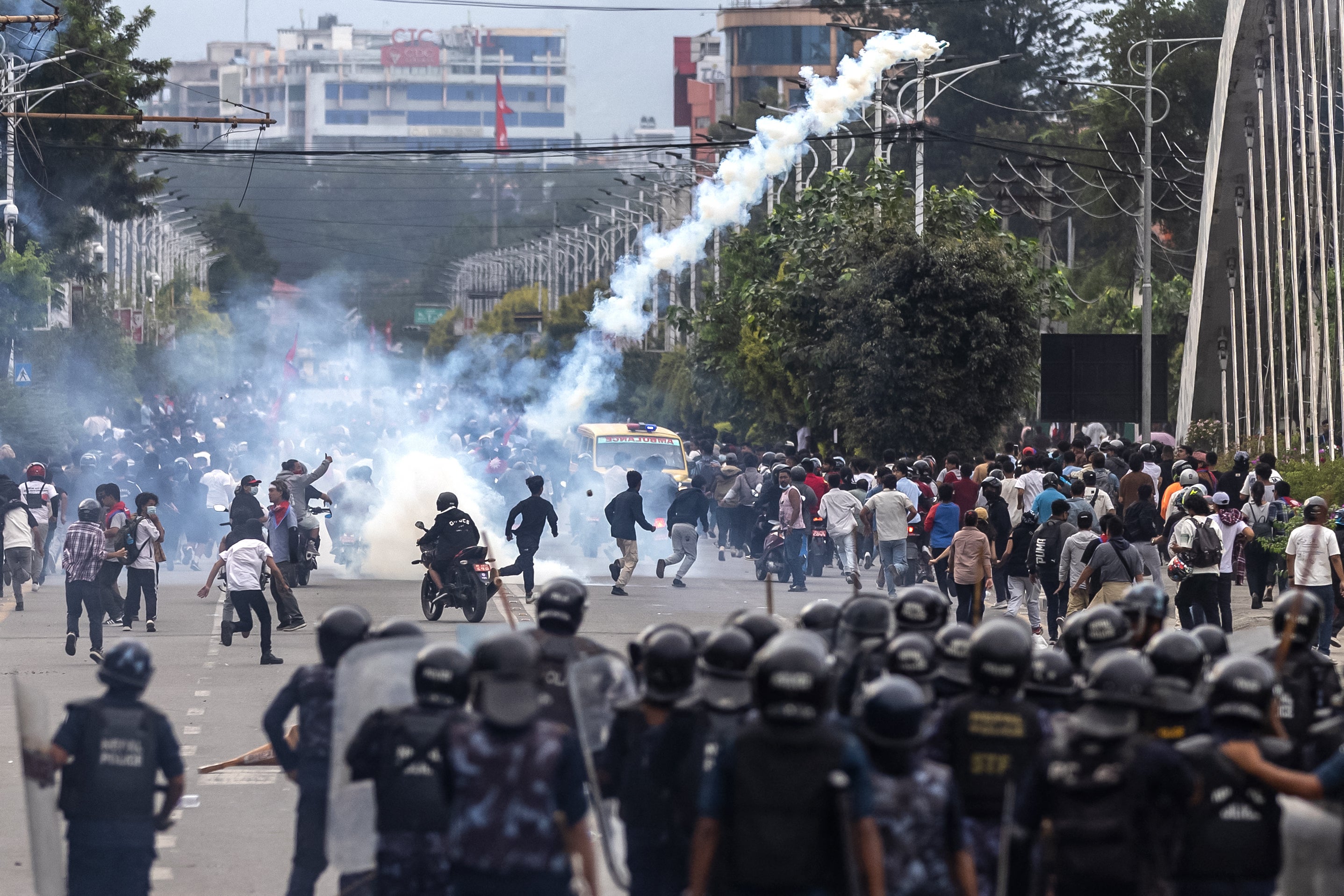 Des policiers antiémeute népalais observaient des manifestants courir après avoir été visés par des tirs de gaz lacrymogène devant le Parlement à Katmandou, au Népal, le 8 septembre 2025.