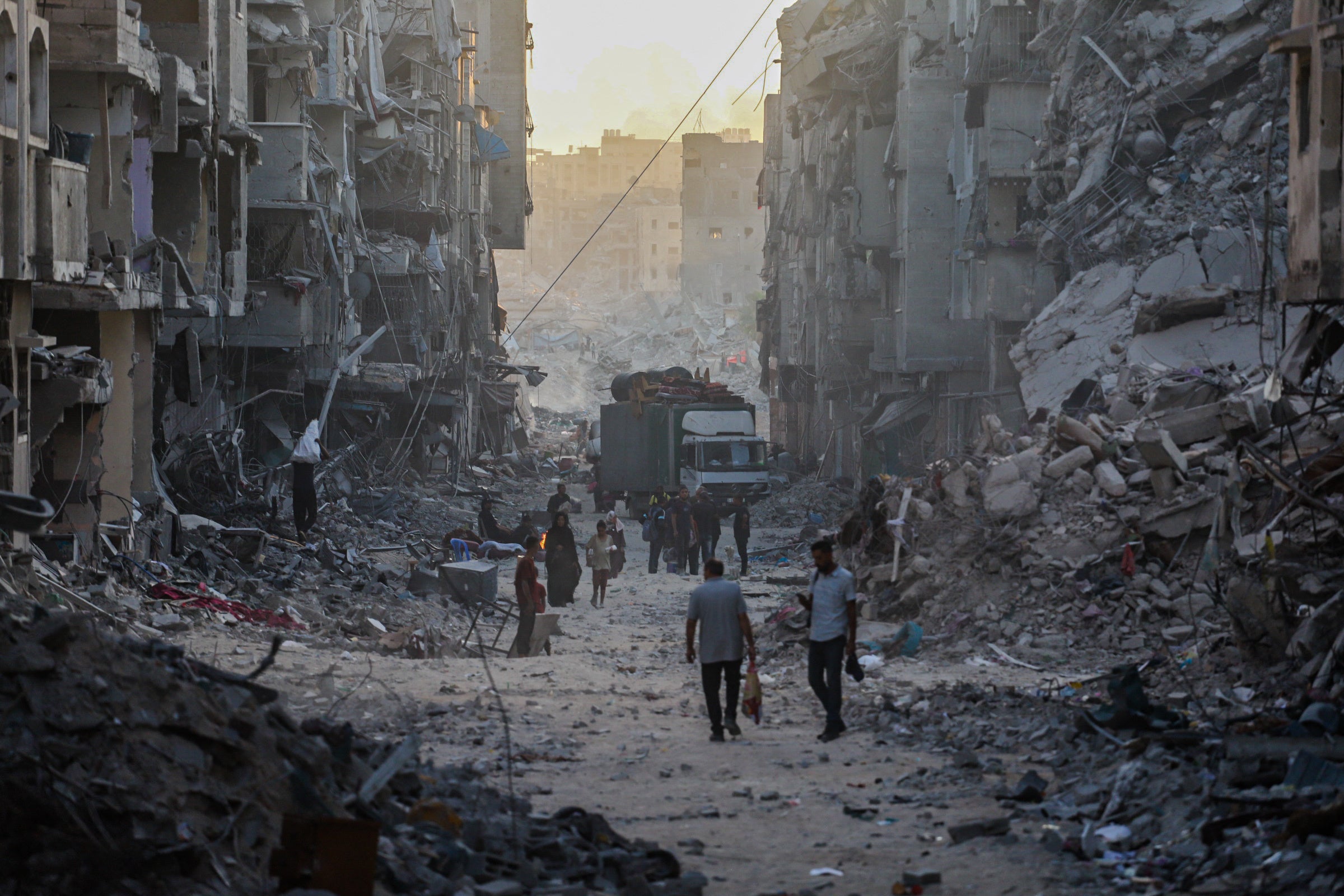 Des Palestiniens marchaient parmi les décombres d'immeubles résidentiels détruits par des frappes israéliennes dans le quartier de Sheikh Radwan, situé dans le nord de la ville de Gaza, le 13 octobre 2025. 
