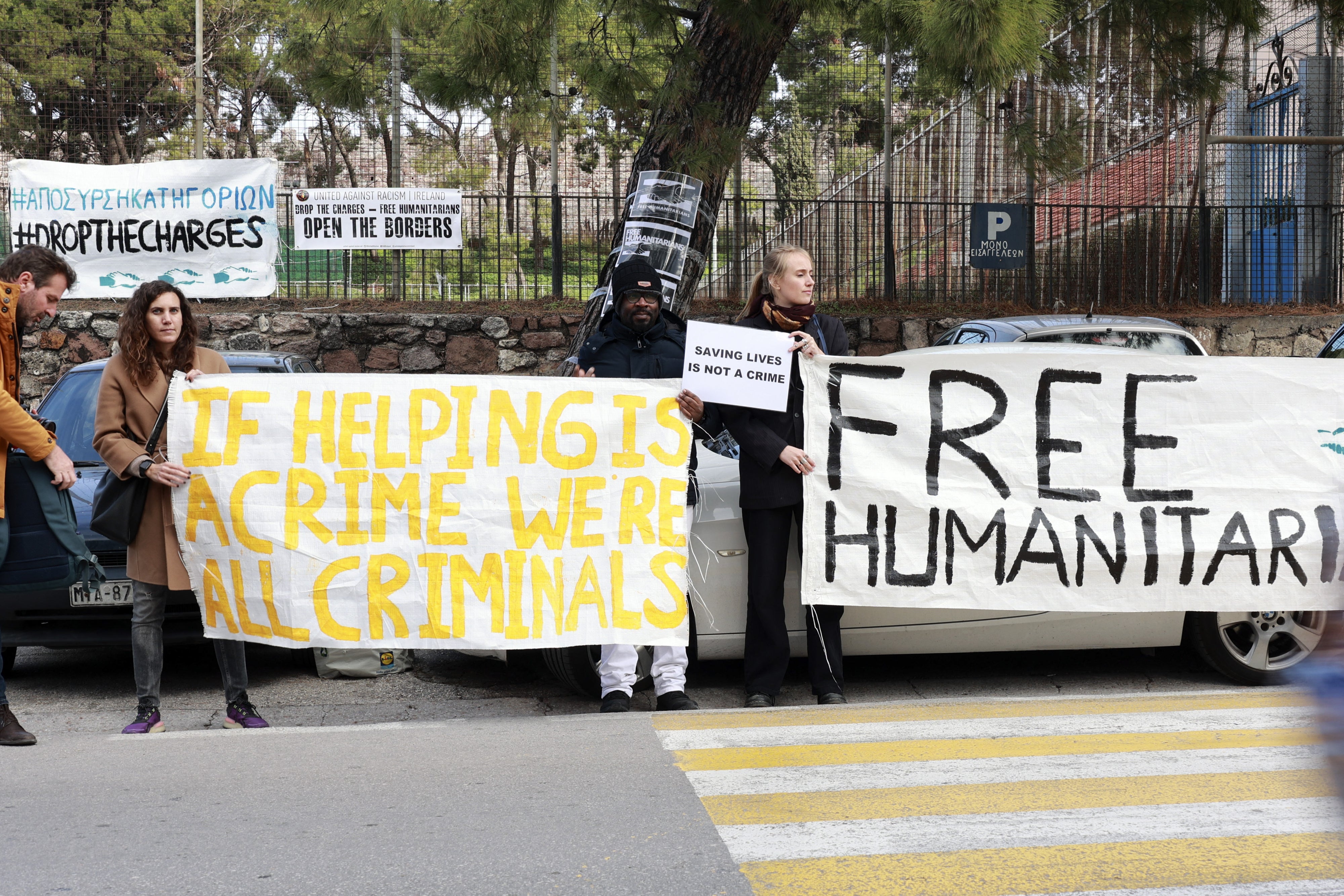 Des manifestants brandissaient des pancartes devant un tribunal à Mytilène, sur l’ile grecque de Lesbos, le 13 janvier 2023, exprimant leur soutien à 24 activistes poursuivis pour avoir aidé à secourir des migrants en mer Méditerranée. 