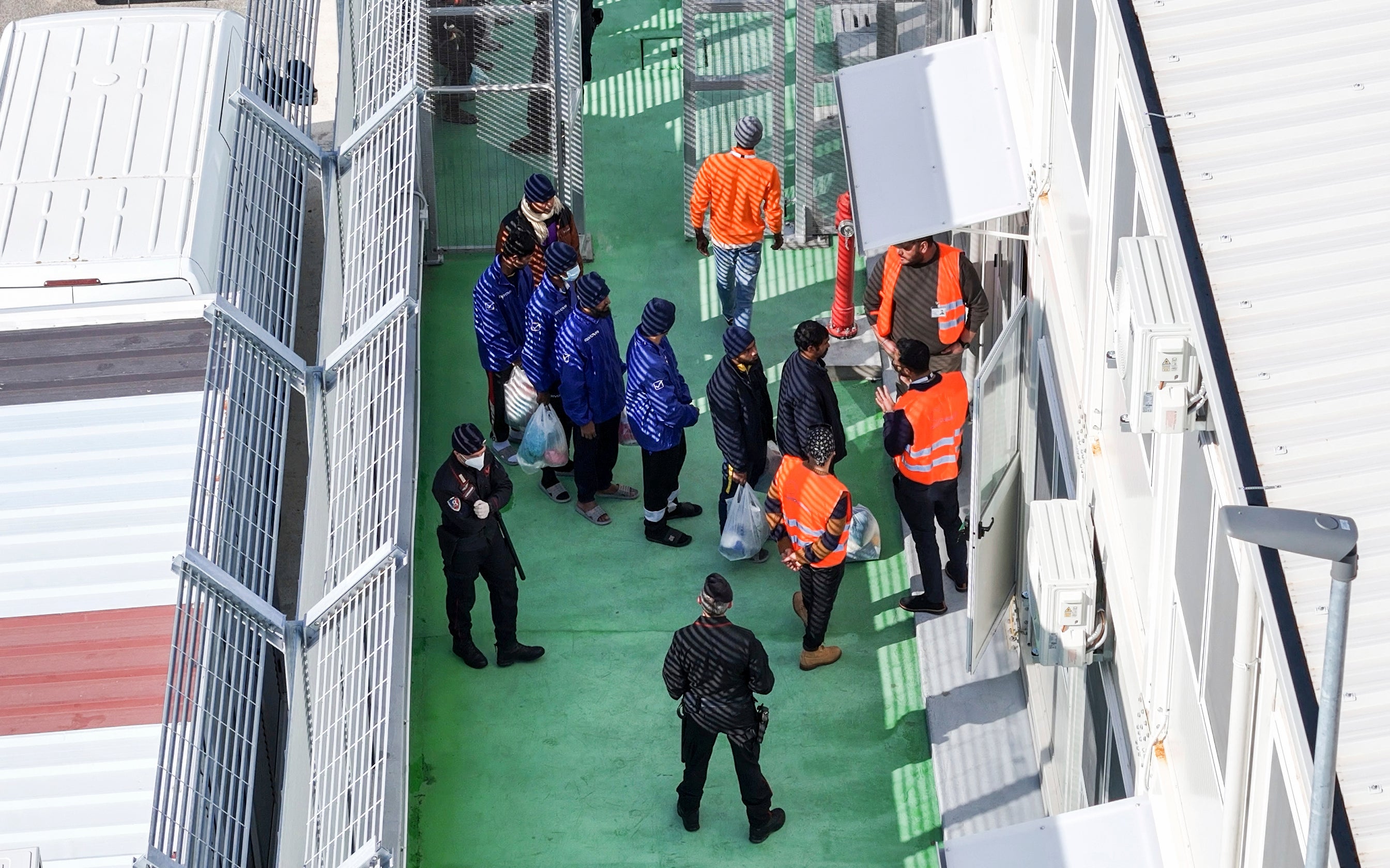 Migrants entering a detention center for processing at the port of Shengjin, northwestern Albania, January 28, 2025.