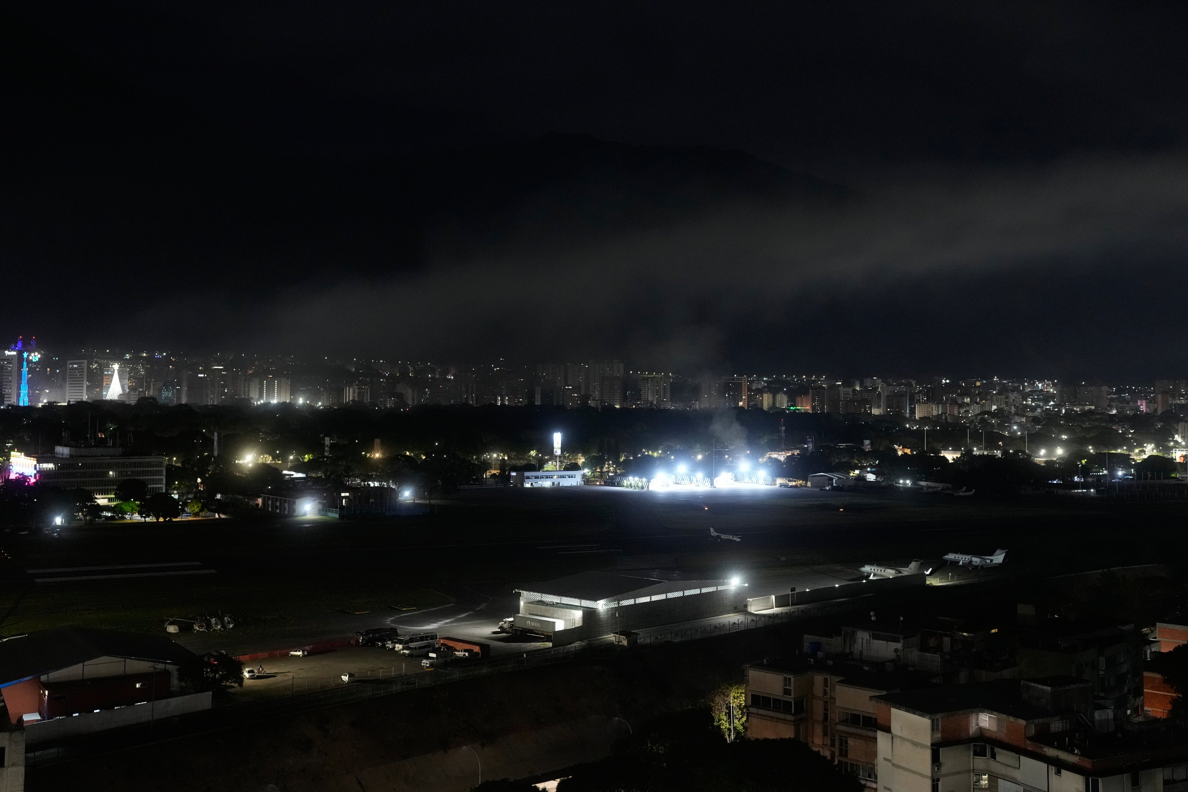Se ve humo en el aeropuerto de La Carlota luego de que se escucharán explosiones y aviones volando a baja altura en Caracas, Venezuela, el sábado 3 de enero de 2026.