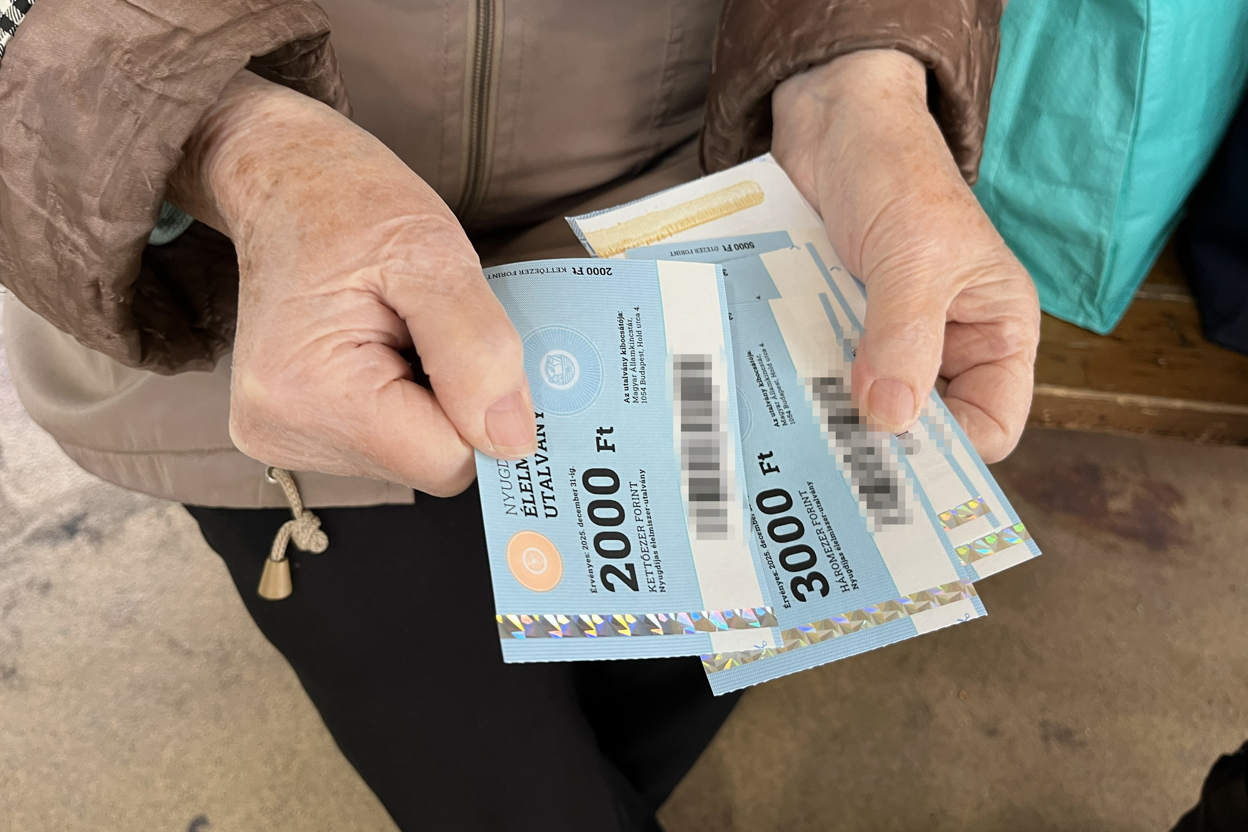 Margit, une femme hongroise âgée de 85 ans, montrait les bons alimentaires qui lui restaient après avoir acheté des fruits sur un marché de Budapest, en octobre 2025. Elle a indiqué que seuls quelques étals du marché acceptaient ces bons.