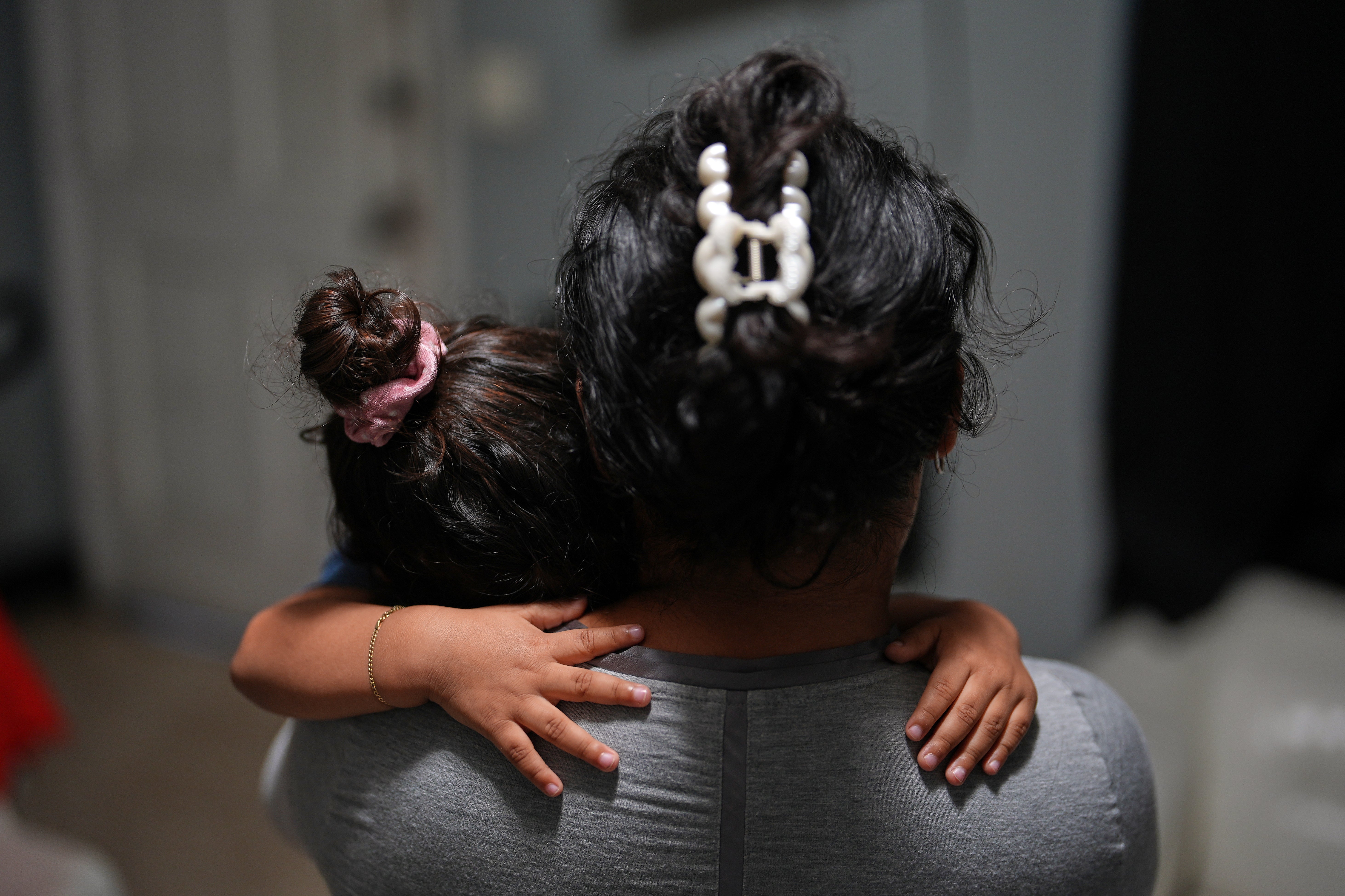 Eine schwangere asylsuchende Frau tröstet ihr zweijähriges Kind in dem Motelzimmer, in dem sie und ihre Kinder nach der Abschiebung ihres Mannes nach Nicaragua leben, in Miami, Florida, 13. November 2025.