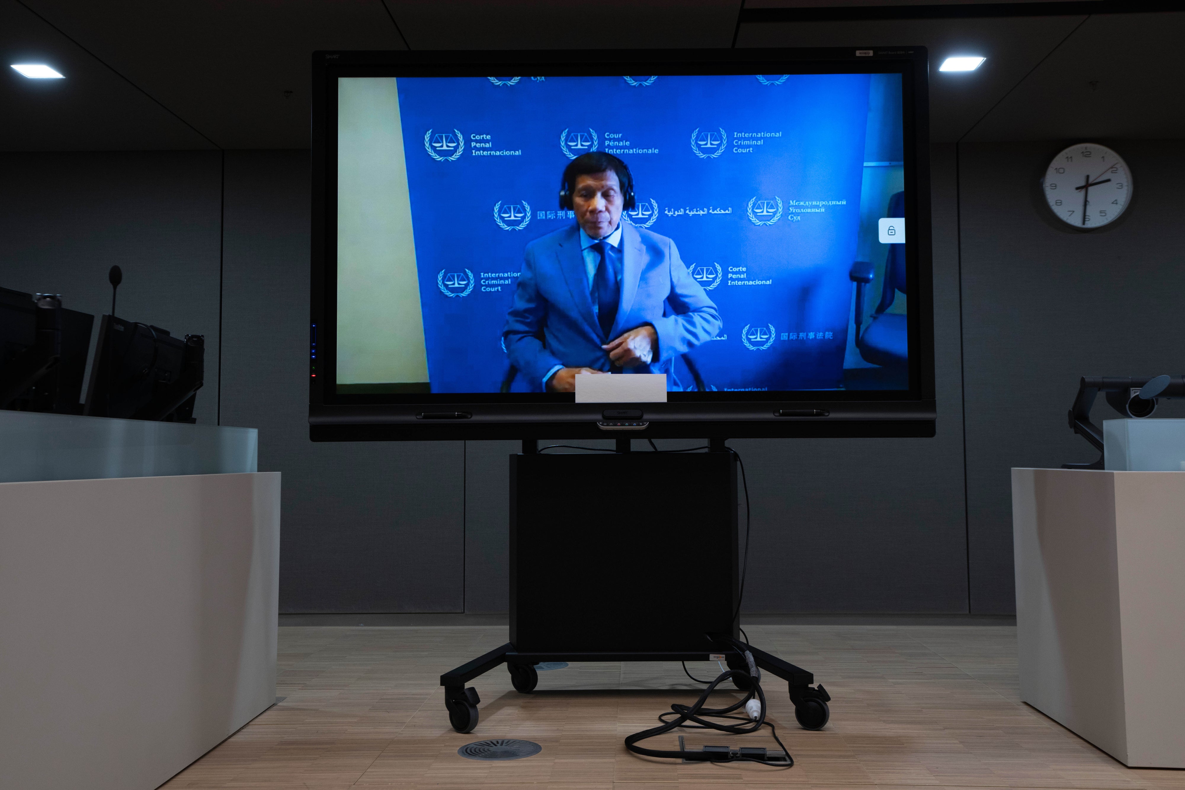 L'ex-président philippin Rodrigo Duterte, visible sur un écran dans une salle d'audience de la Cour pénale internationale à La Haye, aux Pays-Bas, comparaissait via visioconférence devant la CPI le 14 mars 2025.  © 2025 Peter Dejong/AP Photo