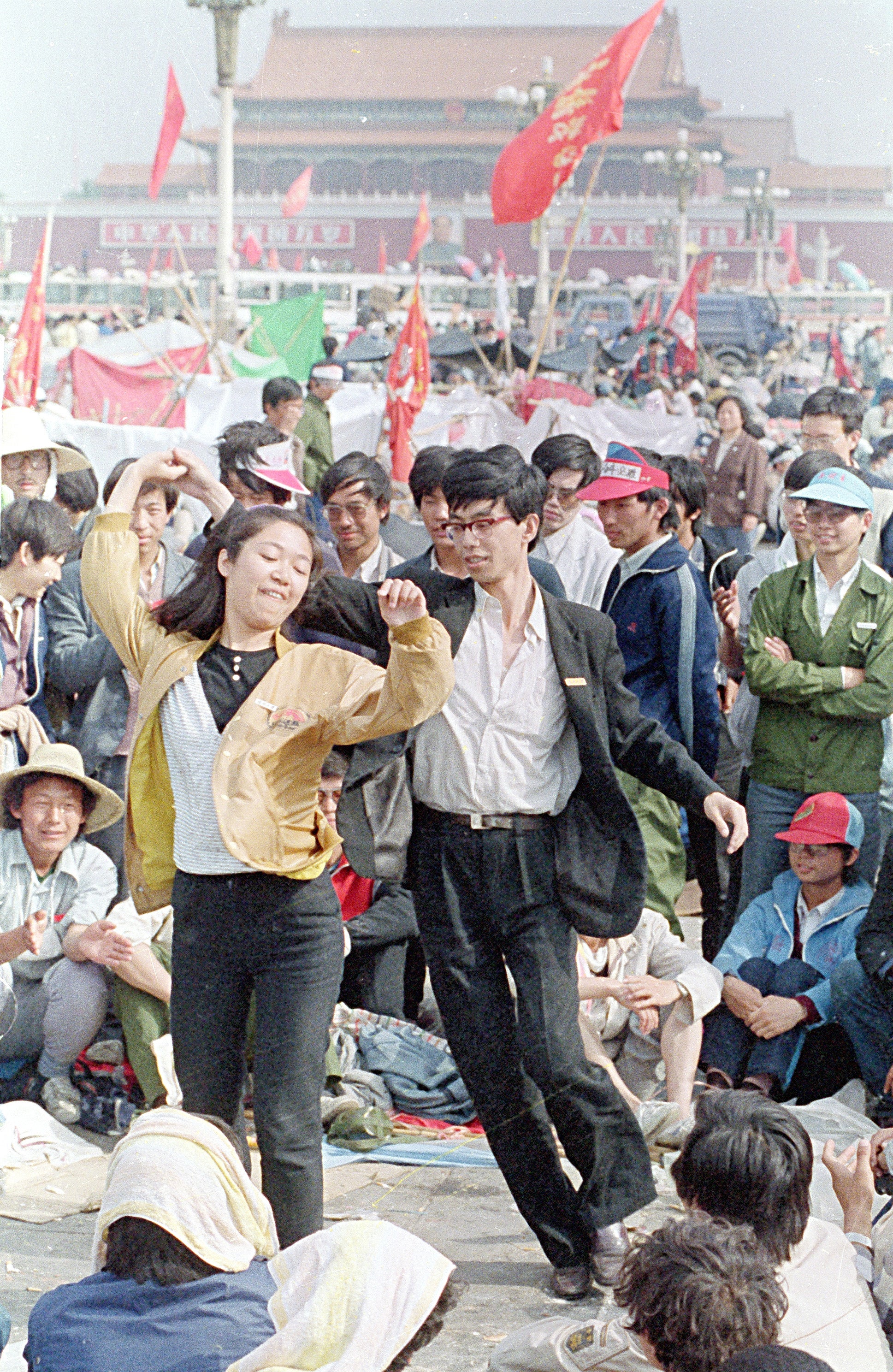 University students dance during the pro-democracy demonstration in Tiananmen Square on May 22, 1989, in Beijing, China. 