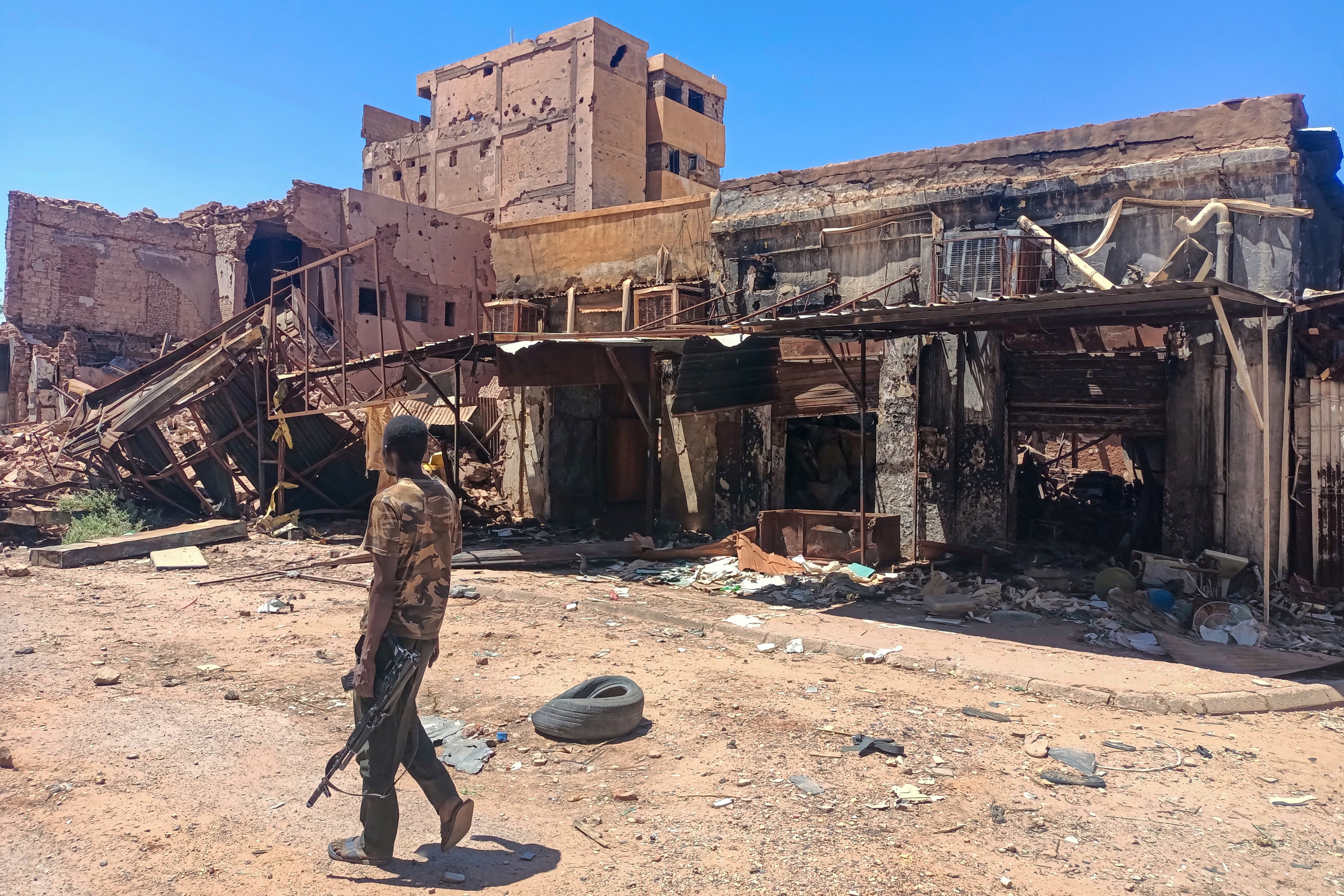 A fighter loyal to the army patrols a market area in Khartoum on March 24, 2025.