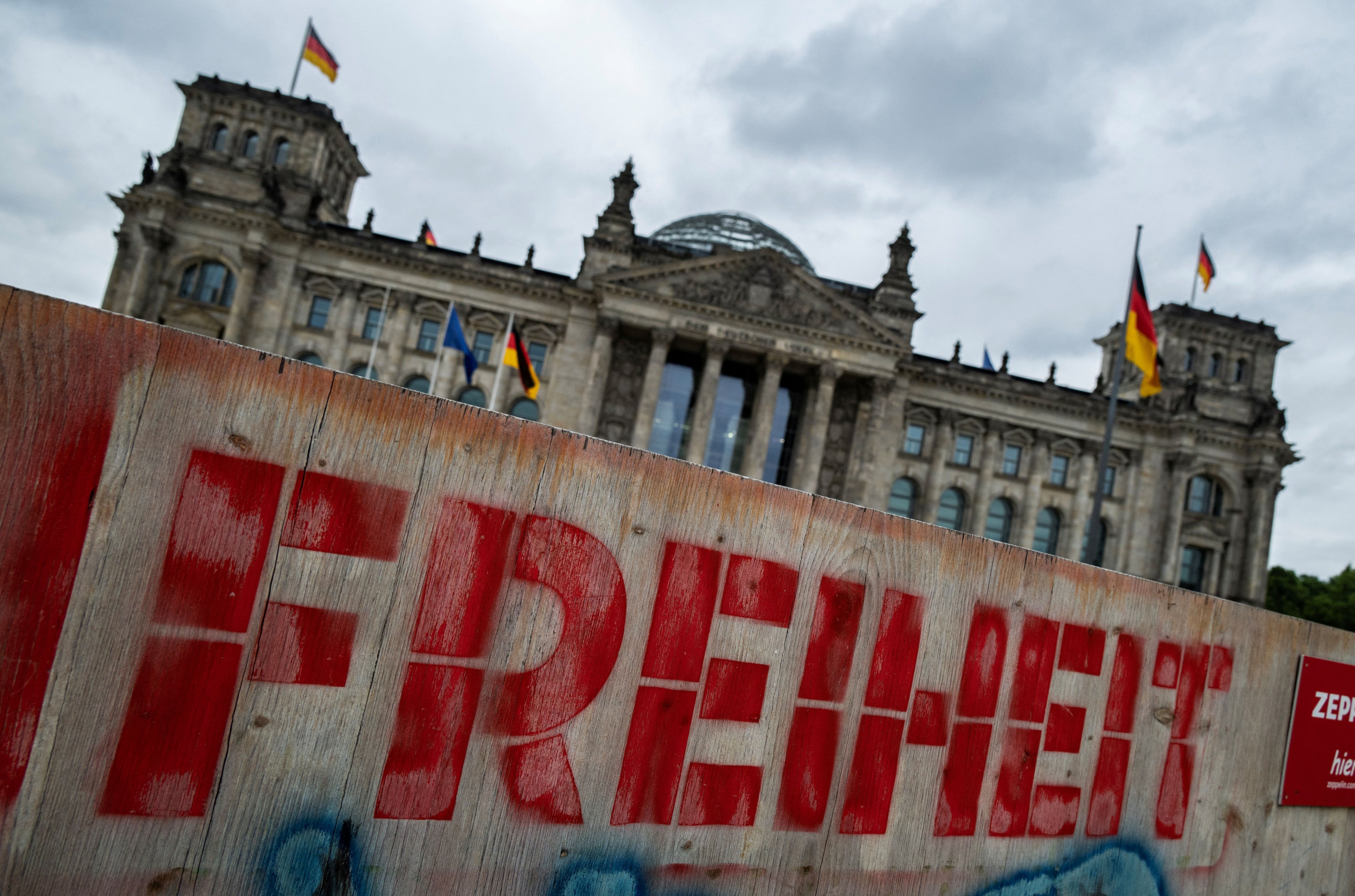 Graffiti on a wooden fence in front of the Reichstag building in Berlin, Germany reads "Freedom," on May 19, 2025.