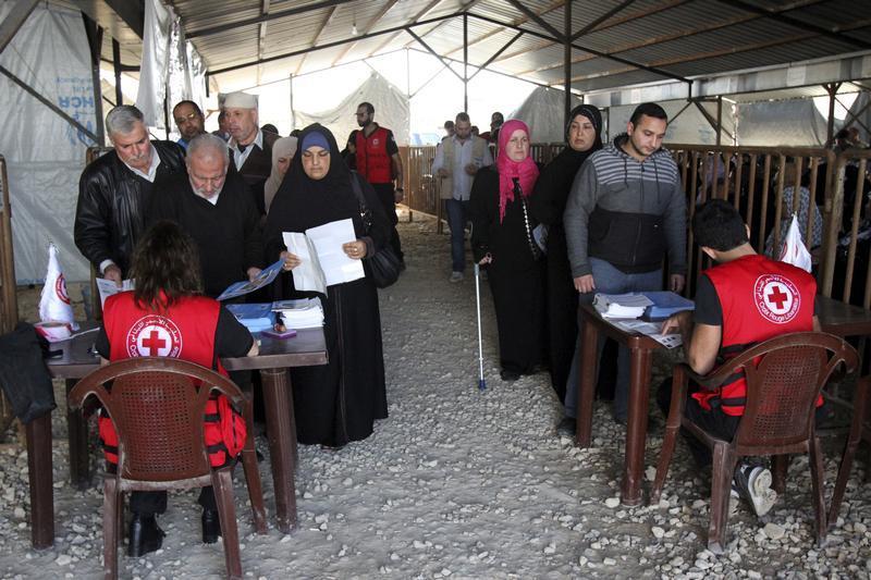 Syrian refugees line up to receive aid for the winter from the UN refugee agency (UNHCR) in Tripoli, northern Lebanon.